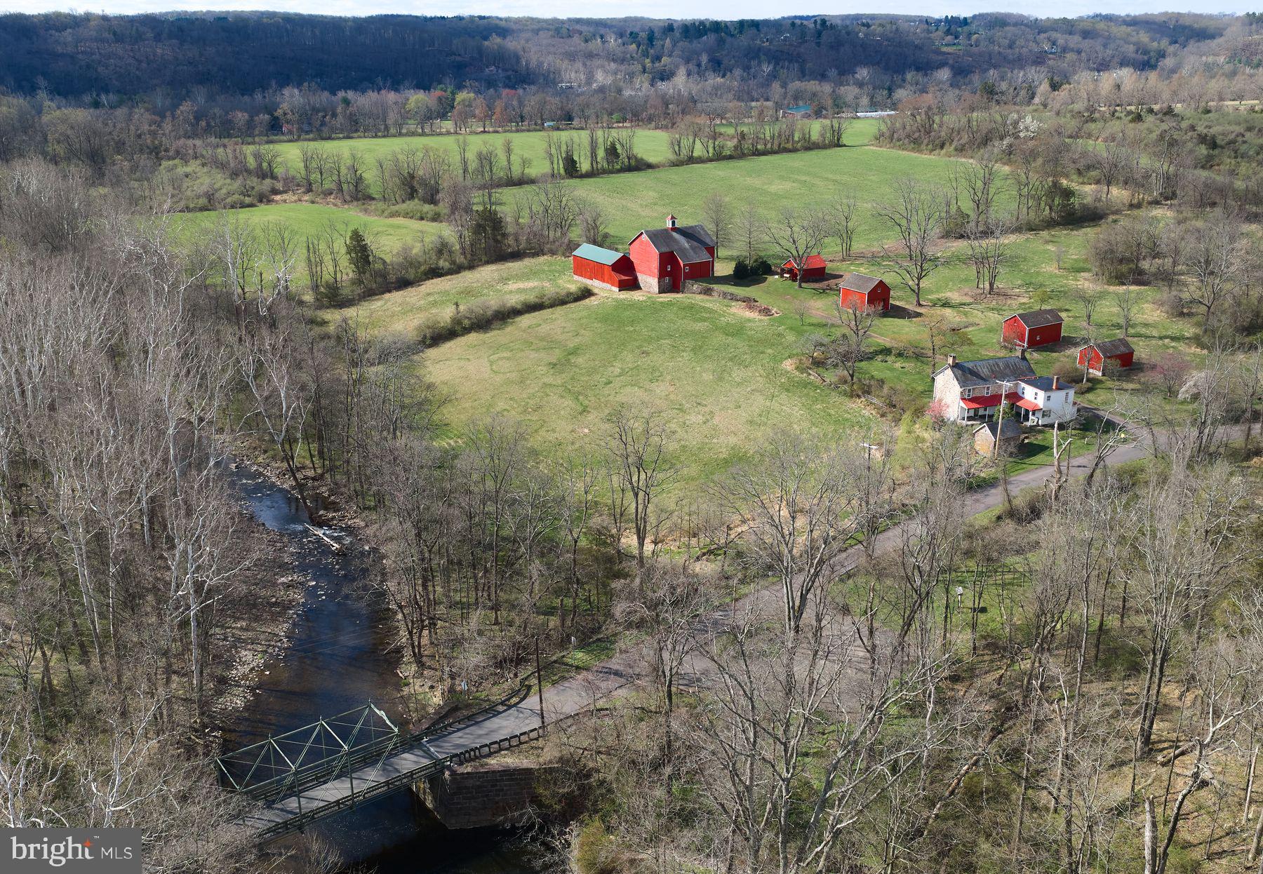 One of the most intriguing parcels of land in Delaware Township, the Zega Farm dates to 1798. 79+ acres of rural serenity, the landscape of open fields meets a quiet wooded grove shading the winding Lockatong Creek. This parcel of land represents one of the last large farms in the area that has not been preserved.The property includes a colonial 18th Century stone farm house with impressive stone quoining and charming fireplaces, a number of farm buildings and a remarkable bank barn with slate roof. Historians have indicated that the barn is notable for both its mid-19th century era of construction as well as its massive size. The barn's cathedral like interior space features impressive hand hewn timbers while the exterior features beautiful masonry work with stone in various shapes, textures and colors.As you begin to explore the farm you will take a walk up the drive towards the barn, where the fields spread out toward the Delaware River Valley and Pennsylvania's distant cliffs offering unobstructed and unparalled views.Looking across the road is yet another beautiful meadow and woodlands which is the preserved Zega Historic Land Trust.The location of the farm is ideal as it is situated on a quiet country road complete with a single lane iron truss span bridge over the creek dating back to 1878. The bridge which a registered national historic site adds additional rustic, old world charm to the property.Located close to the Delaware River and its towpath, the farm is perfectly situated near many shopping and dining venues, numerous orchards and farm markets, antique and art galleries and intimate country inns on both the PA and NJ sides of the river. It is just minutes to the towns of Stockton, Lambertville and New Hope with an approximate commute time of 75 minutes to New York City or 60 minutes to Philadelphia.