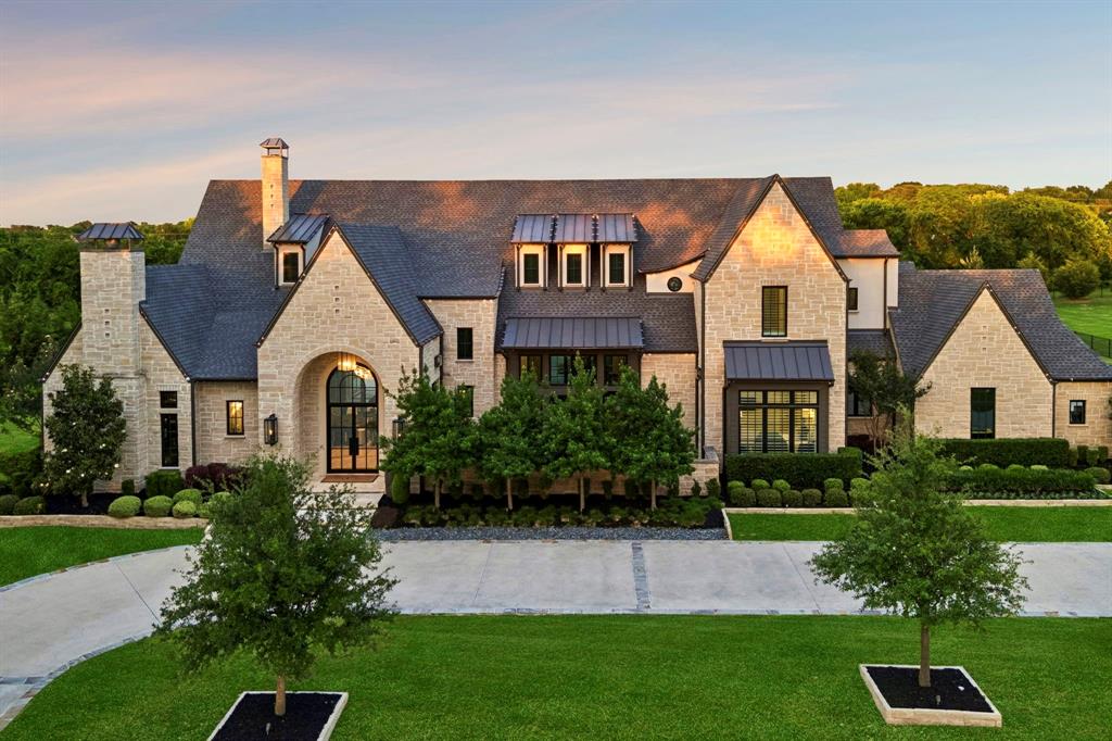 Situated on approximately 2 manicured acres in the exclusive Harper Landing community, 460 Michelle Way is a customized luxury lifestyle estate in highly acclaimed Lovejoy ISD. Spanning 7,425 SF, this custom residence blends striking architectural presence with resort-style amenities rarely found in a single property.Inside, soaring vaulted ceilings with architectural wood and stone-wrapped beams, imported stone and tile selections, designer lighting, and expansive backyard views create a refined yet inviting atmosphere. The chef’s kitchen features dual quartzite islands, Wolf appliances, an oversized walk-in pantry and prep kitchen combination designed for elevated organization and effortless entertaining, wine refrigeration, and a temperature-controlled wine room.Multiple living areas, game rooms, wet bars, and entertainment spaces create seamless gathering areas throughout the home. The private primary suite offers heated bathroom floors, spa-inspired finishes, and a hidden vault room discreetly built into the custom closet. Additional highlights include an executive office with fireplace, curated designer textures, whole-home audio, integrated smart home automation, and a private fitness studio complete with steam and infrared saunas.Outside, resort-style swimming and lap pools, oversized spa, water and fire features, expansive travertine decking, covered lounge and dining spaces, outdoor fireplaces and TVs, motorized shades, and a fully equipped designer outdoor kitchen create an unmatched setting for entertaining. Golf enthusiasts will appreciate the three private tee boxes and professional-grade putting green surrounded by mature landscaping and privacy.Additional features include a 4-car garage, courtyards, and close proximity to Heritage Ranch Golf & Country Club, shopping, dining, and major commuter routes. A rare opportunity to own a fully realized luxury estate where recreation, wellness, and elevated living converge.