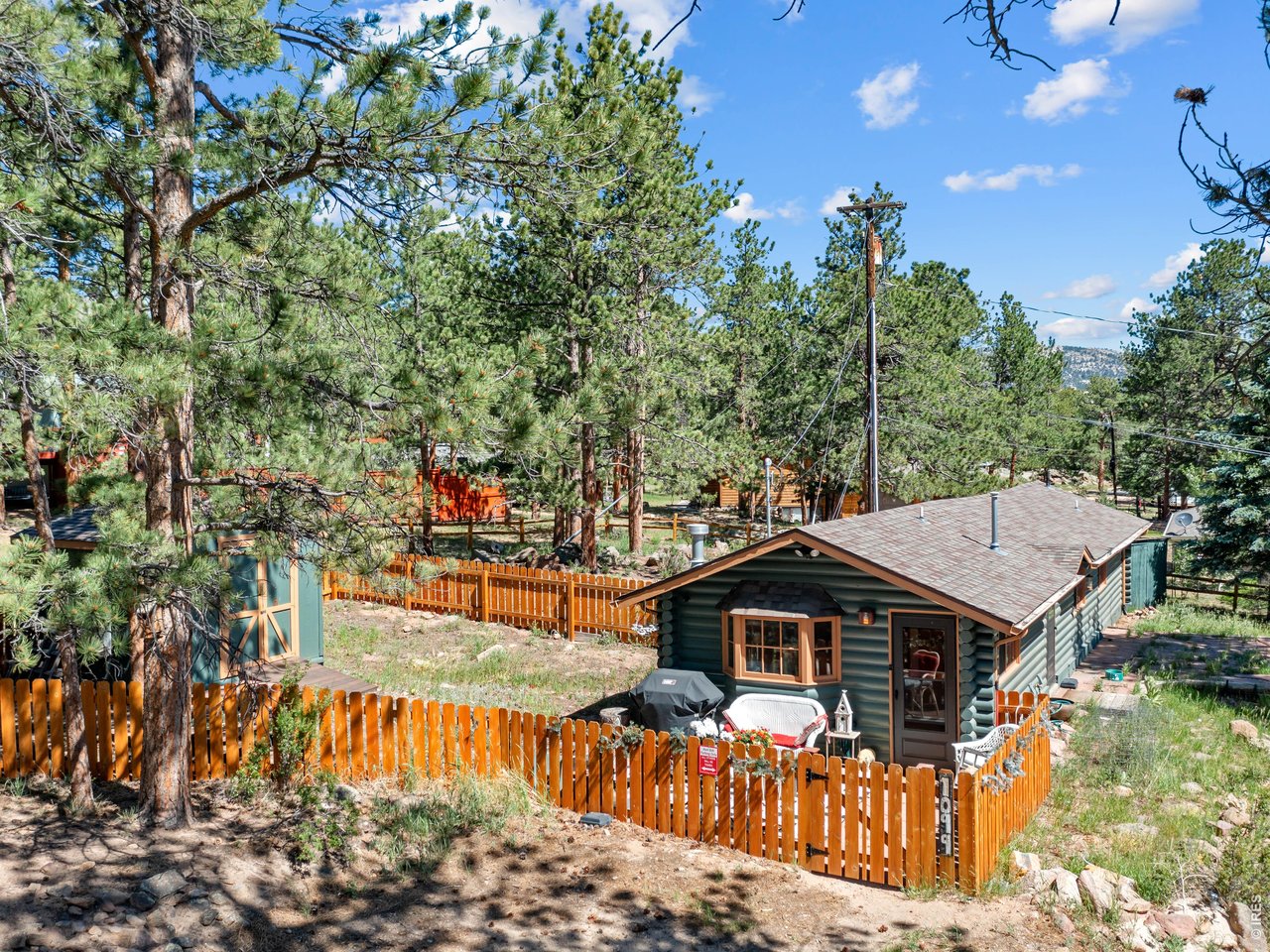 Big adventures often begin in the coziest places, and this charming mountain cottage is proof that great things come in small packages. Perfectly designed for comfort, simplicity, and unforgettable Estes Park memories, this inviting 1-bedroom, 1-bath retreat offers the ideal blend of rustic character, thoughtful functionality, and investment potential with a valuable transferable short-term rental permit already in place. Whether you're searching for your own peaceful mountain escape, or an opportunity to expand your investment portfolio alongside the neighboring home, this property checks all the boxes. Step inside and you'll immediately feel the warmth that makes mountain cottages so special. Tongue-and-groove pine ceilings create an open, airy atmosphere while natural wood accents throughout the home bring the outdoors inside. Large windows invite in sunshine and the surrounding pines, creating a bright and welcoming living space you'll love returning to after a day exploring Rocky Mountain National Park. Even more exciting is its unique relationship to the neighboring property. Situated adjacent to a larger vacation home that is available separately on its own parcel, this cottage presents a rare opportunity. Purchase individually as a standalone investment or personal getaway, or consider the possibilities of owning both properties to create a multi-home family compound or expanded vacation rental portfolio. Opportunities like this are increasingly difficult to find in Estes Park.