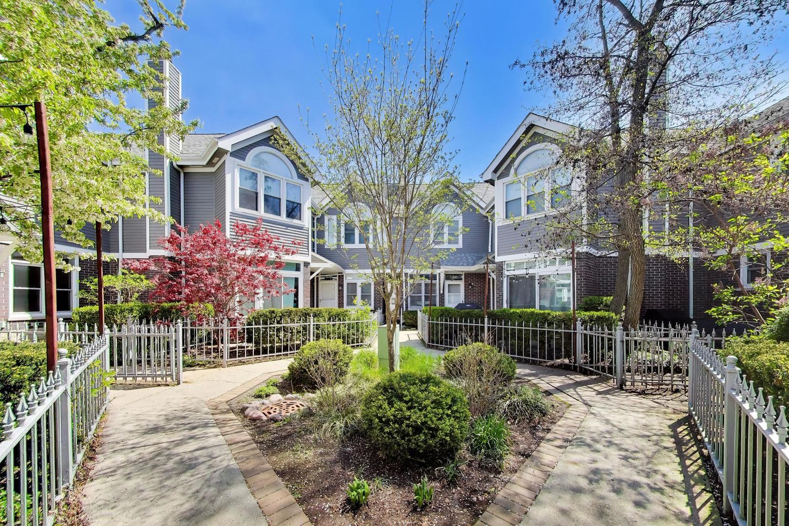 Welcome to 3331 N Racine #D - a meticulous 3 bed/2 bath, end-unit, courtyard townhome in the sought-after Hawthorne Court community and Nettelhorst Elementary. Nestled in Southport Corridor near Wrigley Field in greater Lake View, this recently refreshed residence offers both comfort and convenience in one of Chicago's most vibrant neighborhoods. Set quietly back east off Racine Ave., this home welcomes you with a private, sun-drenched courtyard entrance surrounded by lush greenery. Inside, a south and west-facing open floor plan is filled with natural light, highlighting freshly finished diagonal oak hardwood floors in a classic Jacobean stain, professionally painted throughout, and custom window treatments. The main level features a distinctive on-grade sunken living room with fireplace and comfortable work flex space, flowing seamlessly into a dedicated dining area. The adjacent chef's kitchen is thoughtfully designed with ample shaker cabinetry, custom built-in buffet/dry bar, granite countertops, stainless steel appliances, breakfast bar island, wine cooler, and generous storage. Completing the main level is a spacious, fully fenced private patio - ideal for outdoor dining, grilling, and entertaining. Upstairs, the primary suite offers vaulted ceilings and a custom built (floor-to-ceiling) walk-in closet, while the second bedroom enjoys abundant sunlight from its east and south exposures. The shared bathroom suite includes a dual vanity, soaking tub, and separate shower. The lower level provides flexible living space with a third bedroom or family room, featuring brand-new LVT flooring, an updated full bath, in-unit laundry, and additional storage. One attached garage parking space is included. Located just moments from the dining, shopping, and nightlife of "Southport-Clark-Belmont-Roscoe," perfectly close (but not TOO close) Wrigley Field and nearby transit options. This home is part of a well-maintained, professionally-managed, and gated association in a prime North Side location. Over $40,000 in recent cosmetic and mechanical upgrades.