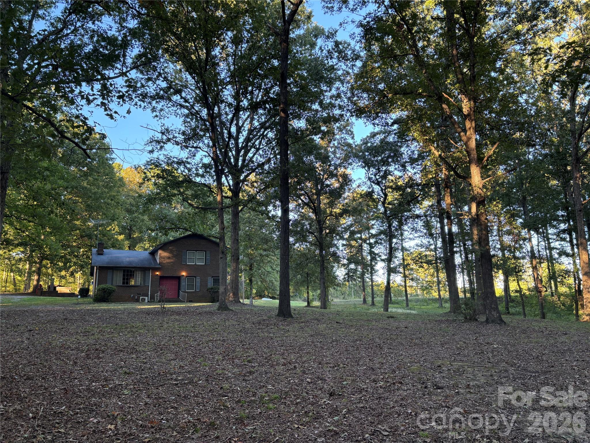 Welcome to peaceful living on this property tucked atop a gently sloping lot and covered by the shade of mature oaks. This split-level home features a spacious living room anchored by a large, custom brick fireplace with dual storage boxes and framed by charming circular windows. A large bay window welcoming plenty of natural light completes the space. A short flight of stairs descends to a bedroom featuring a large closet and en-suite bathroom. A second room downstairs can be used as an office or secondary living area. A short flight of stairs climbing up from the central living room features two additional bedrooms, each with ample closet space and plenty of windows. Each of the bedrooms and living areas feature beautiful hardwood flooring. This home provides the perfect combination of spaces to gather as well as plenty of room to retreat and relax with plenty of opportunities to renovate and upgrade to add your personal style. Located just off Hwy 601, this property features easy access to Monroe, NC and Pageland, SC for shopping and dining.