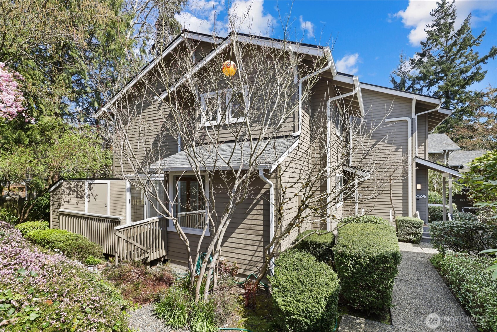 Live in the heart of downtown Bellevue—the true heartbeat of the Eastside. Just two blocks from Bellevue Square, you’ll enjoy world-class shopping, dining, and entertainment right outside your door. Embrace a walkable lifestyle and leave the car behind with everything so close at hand. Meander through the charming garden entrance, this ground-level home welcomes you with a private front porch and lives more like a townhome. As a desirable corner end unit with only one shared wall, it offers added privacy and abundant natural light.  Inside, the open living and dining areas flow seamlessly onto a spacious west-facing deck—perfect for soaking in afternoon sun and entertaining. Large windows fill the home with warm, natural light, while a cozy gas fireplace and convenient main-floor powder room enhance everyday comfort. Upstairs, you’ll find two bedrooms and two bathrooms, including a primary en-suite with a walk-in closet. The second bedroom is currently styled as a home office with a built-in desk, offering flexibility to easily convert back to a bedroom or function as a dual-purpose guest space. Complete with two reserved parking spaces, including one covered, this home offers the perfect blend of comfort, convenience, and location. 101st Place is a dead end street tucked behind the post office and just one block to QFC.
