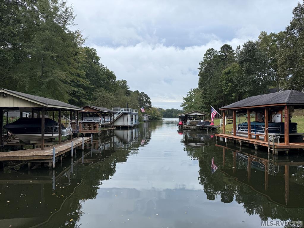 This is a great waterfront lot in Jimmie's Creek with just over one acre of land and seller financing available!!!! Inquire on terms!! With the driveway already cut in, rock laid, and trees partially cleared this one is ready for your custom home build. Directly in front of the lot is the shared boathouse and deeded slip making access to Lake Gaston easy. There is also a private storage closet in front of the slip to keep things like life vests etc. You have to come check this one out!