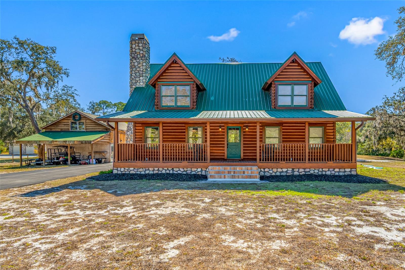 Step inside this beautiful log cabin, quaint and rustic on the outside and a modern day sanctuary inside, all surrounded by close to 9 acres of privacy. The cabin has 3 bedrooms, 2 and a half bathrooms. Come and enjoy the peace and quiet of this hidden retreat on the outskirts of town. Everything has been updated, the kitchen has state of the art appliances and cabinets. Hewn Stone wood Fireplace. There is an outdoor building that is approximately 1800 sq. ft. that can be used for an office, gym, garage or ADU. The home has a garden ready for you to plant vegetables. Sit and relax on the outdoor screened porch and watch the deer surrounding the back of the property. The cabin sits on approximately 3 acres with close to 6 acres next to the home that you can do whatever you want with, no HOA. New roof 2020, New A/C 2022, updated bathrooms, Fenced with automatic gate, new tankless water heater, new water treatment system. No expenses have been spared for this truly one of a kind property. Bonus: Camper comes with the house, excellent condition for guests to enjoy. Just off of Ridge Road, which connects to the Veterans to downdown Tampa, close to shopping, Beaches with a short commute to Tampa airport.