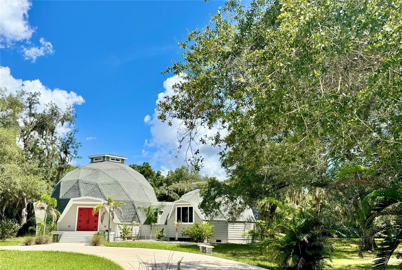 Architecturally Distinctive. Beautifully Reimagined. Entirely One of a Kind.There are houses designed simply to provide shelter—and then there are houses where architecture becomes part of the experience. Set on 1.29 acres at the end of a quiet cul-de-sac in Golden Acres, this extraordinary double geodesic residence pairs sculptural architecture, thoughtful renovation and an exceptional natural setting, with the nearly 600-acre Hidden Lake Project conservation area unfolding beyond its backyard.From the moment you enter, the home's geometry reveals itself. Soaring faceted ceilings, angular openings, clerestory windows and an open upper gallery create remarkable volume while allowing light and sightlines to travel through the residence in unexpected ways. Here, the architecture isn't simply admired from the outside—you live within it.The extensively reimagined 3-bedroom, 2-bath main residence balances its unconventional form with warm, enduring materials. Oak hardwood floors flow through the principal living areas, while natural slate lends richness and texture to the entry, dining room and library.At the heart of the home, an extraordinary living room unfolds beneath the dramatic geometry of the dome. A gas fireplace framed by angular windows anchors the space, while the upper gallery and elevated clerestory draw natural light into the center of the structure. Nearby, the separate dining room sits slightly elevated on natural slate, framed beautifully by the architecture surrounding it.The large eat-in kitchen was designed for both gathering and cooking, with white cabinetry, stone countertops, a substantial island with farmhouse sink, gas convection range, wine cooler and walk-in pantry.Two bedrooms and a full bath occupy the main level. Above, the primary suite becomes a private retreat with an en suite bath and intimate loft-style library overlooking the remarkable spaces below.Separate from the main residence, a substantial detached garage offers two generous vehicle bays with 8-foot garage doors plus a dedicated workshop. Above is a complete 2-bedroom, 1-bath apartment with full kitchen, living room and private deck sheltered by an awning—exceptional space for extended family, guests or multigenerational living.Yet perhaps the property's greatest luxury is one that cannot be recreated. Beyond the 1.29-acre homesite lies nearly 600 acres of conservation land, providing an extraordinary natural backdrop and a rare sense of privacy and permanence.Major improvements include the roof, siding, windows, doors, kitchen and bathrooms, creating an unusual convergence of distinctive geodesic architecture and thoughtfully renewed living.This is a property for someone who values individuality over convention, architecture over sameness and a connection to the natural world.Some homes are memorable because of how they are decorated. Others because of where they are built. This one is memorable because there simply isn't another one like it.It isn't a home designed to look like everything else. It was never meant to be.