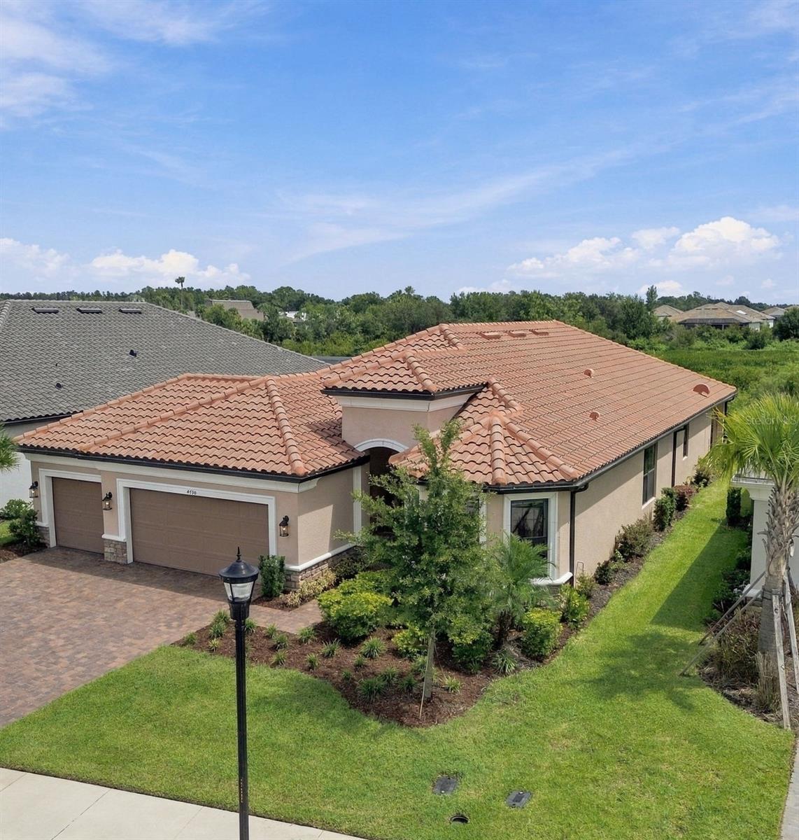 Enjoy resort style living at Esplanade at Wiregrass in this highly desired Lazio floorplan featuring 2,320 SF, 3 bedrooms, 3 baths, plus an office/flex room, a 3-car garage on a beautiful conservation lot.  You will notice the attention to detail as you enter this bright and open floor plan, kitchen overlooks a large family room and dining room, featuring 42” solid wood cushion close cabinets with crown molding, quartz counters, under cabinet LED lighting, and upgraded stainless steel appliances. The oversized quartz island with an ample walk-in pantry and extra counter space, are all designed for entertainment.  The owner’s expanded suite with tray ceiling, crown molding, dual sinks, shower with dual heads and tile to the ceiling, an expanded closet, and extra vanity drawers. The family room boasts coffered ceilings with crown molding, and lots of natural light. Bedroom two has an ensuite bath and bedroom three has a bay window extension. This one-story Taylor Morrison custom home has an open floor plan with an extensive list of upgrades. These upgrades include but are not limited to an office/flex room with French doors, dining room, designer tile floors throughout in common areas, quartz counters and custom tile in baths, extended paver driveway, tile roof, gas tankless water heater, large laundry room with cabinets, a drop zone, water softener and an expanded outdoor patio. Step out on to the extended covered lanai, to enjoy the custom outdoor kitchen that includes a grill, sink, fridge and vented hood so you will be ready to enjoy the Florida outdoors overlooking this premium conservation lot. Esplanade of Wiregrass Ranch is a gated 55+ with a luxurious upscale club house with full-time lifestyle and fitness directors. The Venue includes a resort style pool, hot tub, pickleball, tennis bocci, cabanas, dog park, state-of-the-art 24-hour fitness center, billiard/card room, and a spa room. For active outdoor entertainment there is a firepit, tennis, pickleball, bocci, and a large meeting/gathering area.  Esplanade also includes worry free yard maintenance, reclaimed water, Spectrum TV and internet package included in fees. This home is located only minutes from shopping, I-75, hospitals, restaurants, recreation, and entertainment.  Come see for yourself this beautiful residence and relax, you have found your home. Please see walkthrough and 3D tours.