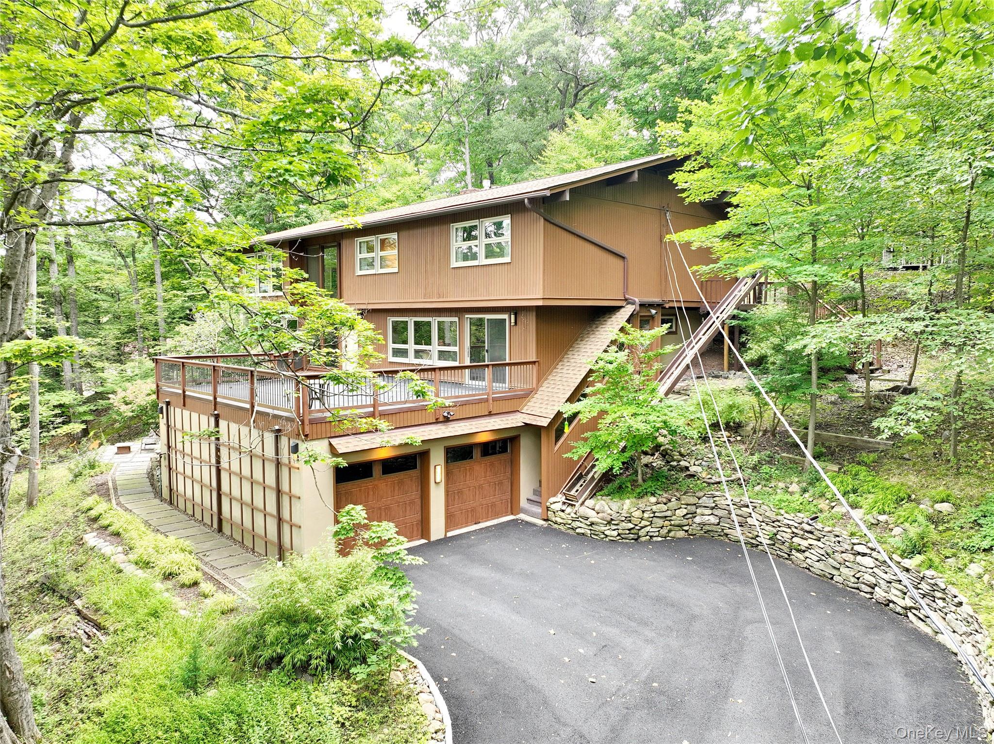 Wesley Hills! What a find! Stunning mid-century modern 4–5 bedroom home set on a wooded property offering privacy and serene views. This residence has been meticulously maintained with only the finest finishes and fixtures throughout.

The heart of the home is a high-end modern kitchen by Executive Cabinetry, Greengard Gold certified, featuring stainless steel appliances including a Sub-Zero refrigerator and custom Ann Sacks tile backsplash. Walls of glass bring the outdoors in, complete with custom window treatments and a motorized shade for the dramatic palladium window. Hardwood floors flow throughout the upper level, while floating stairs accent the striking two-story entry.

The lower level is bright and inviting, offering a spacious great room and office/bedroom. Additional highlights include: irrigation system, water softener, gas fireplace with reclaimed wood mantle, and built-in closets. Recent upgrades: 3-year-old roof, 2-year-old driveway, new Belgian block curbs, and a high-efficiency direct-vent Utica boiler.

Enjoy outdoor living on the patio outside the dining area from Marvin sliding glass doors or the porch above the oversized 12' × 26' two-car garage. Designer touches abound with Murano glass and alabaster sconces. This special home combines a rustic feel, luxury, and tons of privacy.