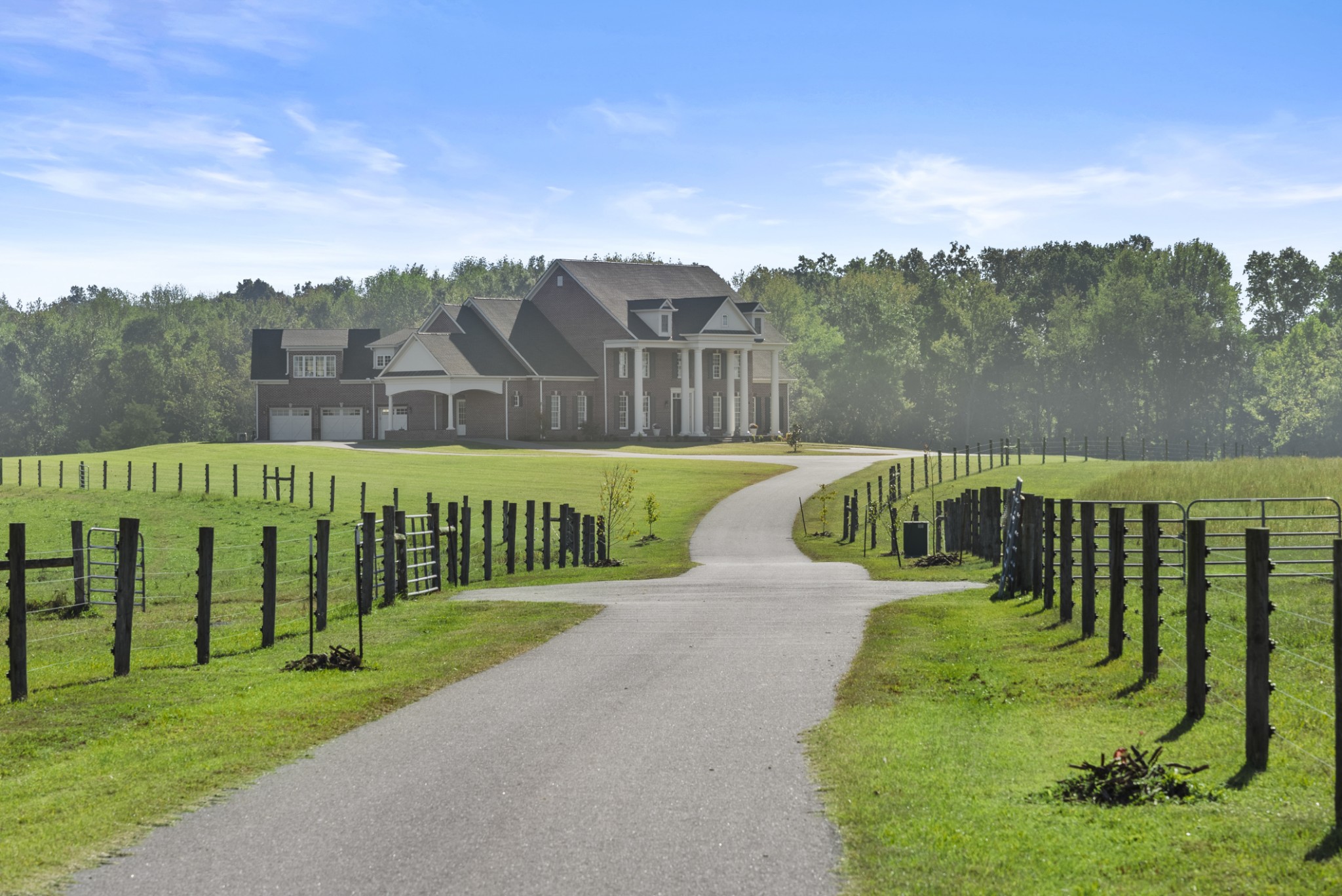 Positioned just minutes from I-24 and within 35 minutes of downtown Nashville, this 424± acre legacy farm represents a rare opportunity of production-ready cattle infrastructure, long-term land value, and estate-quality living.The land unfolds across gently rolling pasture accented with black fencing, creating both visual distinction and operational strength. Fully fenced and cross-fenced with electric high tensile fencing, the farm is supported by city water servicing all 12 livestock watering stations, multiple ponds, and an extraordinary 15,483 feet of road frontage.The cattle infrastructure has been thoughtfully designed to support efficient herd movement, low-stress handling, and streamlined labor. Improvements include a cattle handling facility outfitted with a Foremost headgate with integrated scales, WW chutes and corral panels forming a cohesive working system, a 5,000 sq ft metal barn, 1,968 sq ft barn, 1,280 sq ft barn, 780 sq ft barn, and a 1,240 sq ft shop with dual overhead doors. This is not a patchwork farm, it is a purpose-built, integrated cattle operation.At the heart of the property stands a 6,181 square foot custom residence built in 2016. Designed for both comfort and durability, the home features 4 bedrooms and 5.5 baths, elevator service to all levels, generator, irrigation system, heated and cooled basement garage, and a 3,277 sq ft unfinished basement offering expansion potential. Refined finishes, vaulted wood ceilings, quartz surfaces, and functional layout provide estate-level living without sacrificing practicality.The property also includes three additional homes. One of which has a nice detached garage. With natural gas and city water in place, exceptional accessibility, and significant frontage, this property offers more than immediate agricultural utility, it represents a strategic land investment in one of Middle Tennessee’s most dynamic growth corridors.