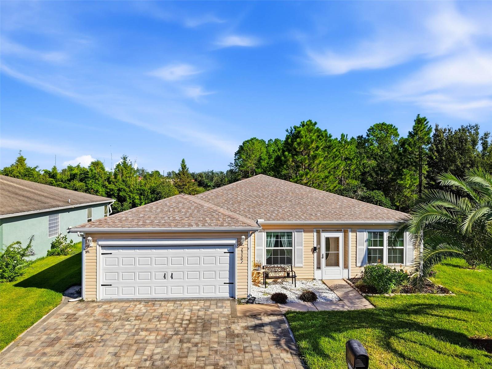 Past the guard gate at Tampa Bay Golf & Tennis Club, a 55+ community, this 2-bedroom, 2-bath home sits on a corner lot with wooded conservation behind it. The only thing looking into your backyard is the trees. Inside are 1,421 square feet with a 10x13 den that's ready to be an office, a craft room, or the place the treadmill goes to be ignored. The enclosed lanai opens through French doors from both bedrooms, so morning coffee is about twelve steps from bed. The primary bath has been remodeled with a soaking tub and a tiled walk-in shower. The rest of the home carries vinyl plank floors, stainless kitchen appliances, double-pane windows, a 2024 roof, a 2024 Lennox HVAC system, and a 2-car garage with a screen door for the breeze. There's no CDD, and the HOA covers cable and high-speed internet. Step outside and you have an 18-hole championship course and a 9-hole executive course, a clubhouse, pools, a fitness center, tennis and pickleball courts, and a calendar full of clubs and activities. I-75 and SR 52 are minutes from the gate, and Wesley Chapel shopping is a short drive. Come see the view from the lanai for yourself!