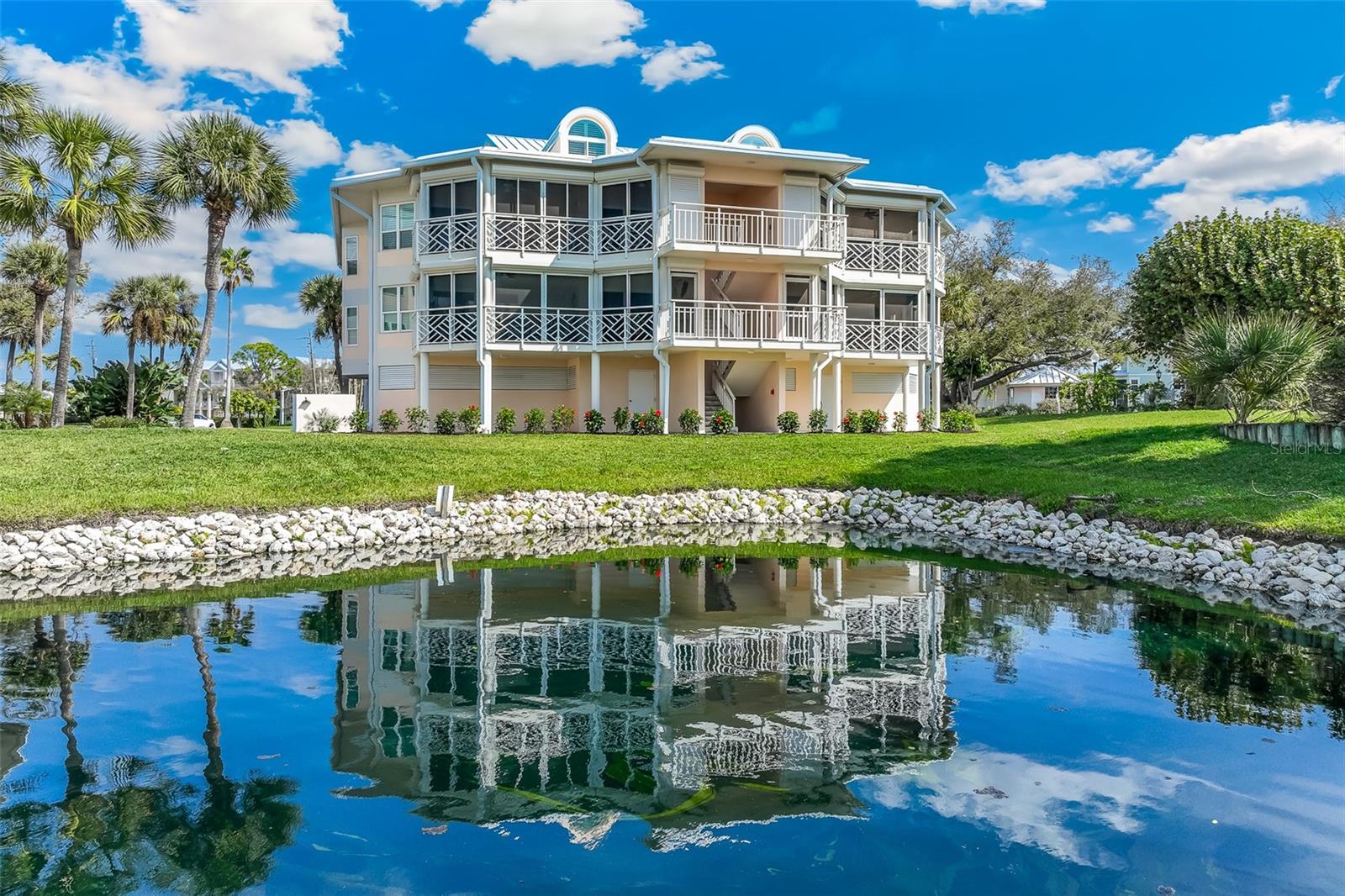 Located within Placida Harbour Club, this first-floor, two bedroom, two and a half bathroom waterfront residence with nearly 2,000 sq. ft. represents a rare opportunity for the discerning buyer to create a custom sanctuary at a tremendous value. This floor plan offers the proven versatility to be expertly reimagined as a three-bedroom residence, a refined conversion successfully embraced by other owners within the community with this floor plan to maximize both utility and value.  The crown jewel of this ownership is the private ferry service aboard the “Island Passage II” to the Placida Beach Club on Little Gasparilla Island, offering miles of secluded Gulf-front beaches, a private island clubhouse, and a beachfront pool...an "Old Florida" escape accessible only to members and residents. Positioned to capture serene water views and refreshing salt breezes, this building with long boat basin views framed by mature landscaping has a brand new roof, fresh paint, new landscaping, elevator access, two-car under building tandem parking, and a spacious exterior storage closet for all your golf, boat, and beach essentials.  The Placida Harbour Club has undergone an incredible transformation over the last four years.  Residents enjoy an unparalleled amenity package including a brand new, fully remodeled deep-water marina, three heated pools, tennis and pickleball courts, and fitness facilities. This is a premier opportunity to build immediate equity in a sought-after community while designing a home that perfectly reflects your style.