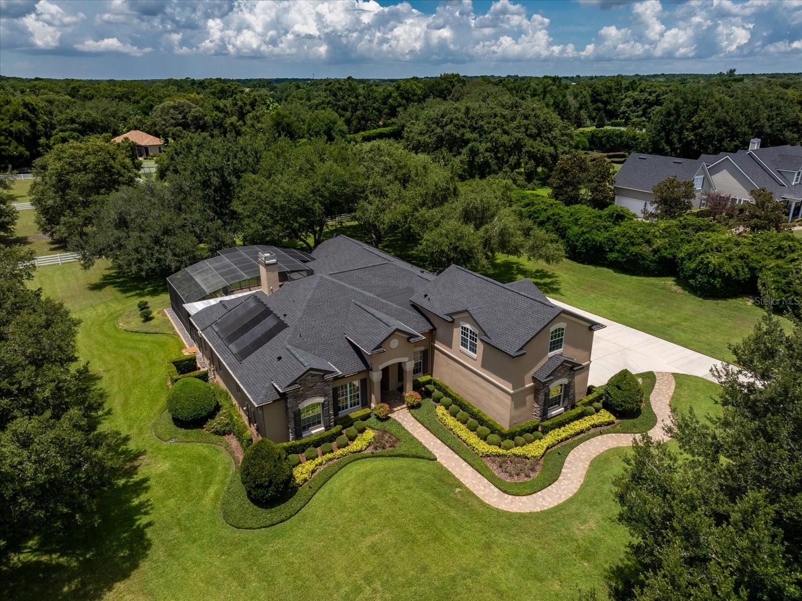 Luxurious estate home in Bluegrass Estates, where country living meets refined elegance. Welcome to 250 Kentucky Blue Circle, a breathtaking estate in the sought-after gated equestrian community of Bluegrass Estates, one of Apopka’s best-kept secrets. As you enter the neighborhood, you’re greeted by a stunning canopy of mature oak trees, setting the tone for the serenity and beauty that await. This exceptional five-bedroom, three-full-bath, two-half-bath home with a three-car garage has been thoughtfully updated and impeccably maintained. Featuring a new roof (2023) and all new air-conditioning units (2024), the home blends comfort, luxury and peace of mind. The main level showcases an inviting open layout, including a spacious family room, kitchen and breakfast area, all overlooking the patio and pool through 8-foot sliding glass doors. Separate living and dining rooms provide elegant areas for gatherings and entertaining. The split floor plan offers a private primary suite, thoughtfully separated from the additional bedrooms. Go outside to your outdoor oasis, complete with a solar-heated pool, above-ground hot tub and a generous covered patio ideal for year-round enjoyment. For those seeking space or multi-use flexibility, the oversized upstairs bonus room sits above the garage and includes its half-bath, sink, mini refrigerator and a private balcony, ideal as a media room, guest retreat or creative space. Equestrian lovers will appreciate the two fenced acres, four-stall barn, tack room and wash rack, along with a dedicated well for all irrigation needs (city water services the home). Bluegrass Estates offers over three miles of scenic riding trails, plus an arena for jumping and schooling, making it an equestrian paradise. Amid exciting new growth along Kelly Park Parkway, this estate offers a peaceful retreat with easy access to new restaurants, shops and upcoming development. Discover luxury, acreage and equestrian living at its finest in the heart of Apopka. Your dream lifestyle awaits at 250 Kentucky Blue Circle.