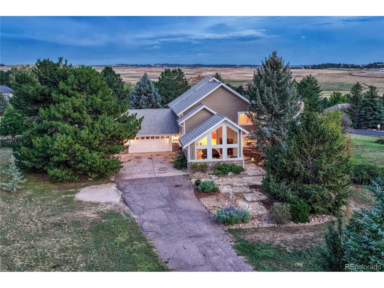 An extraordinary opportunity in the highly coveted Chenango neighborhood, where expansive acreage, breathtaking mountain views, and refined luxury come together in a private retreat. Set on nearly 2.25 acres, this immaculate property is surrounded by mature trees and tranquil privacy, with sweeping views stretching from Pikes Peak across the Rocky Mountains. Currently the only property available in Chenango carrying more than two acres makes this home a truly rare offering.Inside, the home has been thoughtfully updated with sophisticated luxury finishes and an effortless blend of elegance and comfort. The main level is designed for both grand entertaining and everyday living, featuring a dramatic great room, inviting living room, formal dining room, and a spectacularly scaled kitchen. The oversized kitchen is complemented by an incredibly spacious scullery complete with a wet bar and wine refrigerator-an entertainer's dream and an uncommon luxury.Upstairs, the serene primary suite captures a sweeping mountain panorama, creating a breathtaking backdrop from the moment you wake. Two additional bedrooms, three full bathrooms, and a conveniently located laundry room complete the upper level.The light-filled walk-out lower level offers remarkable flexibility, featuring an additional bedroom, 3/4 bathroom, private library, and versatile wrapping room that could easily serve as a gym, workshop, creative studio, or hobby space.Outside, expansive grounds provide abundant space for recreation, entertaining, and enjoying the peaceful setting. Mature trees enhance the sense of seclusion while sweeping mountain vistas elevate the experience.This is the best of both worlds-an estate-like setting where privacy, acreage, and spectacular views create a true escape, yet remarkably close to shopping, dining, schools, recreation, and everyday conveniences. A rare Chenango estate that feels worlds away while being close to everything.