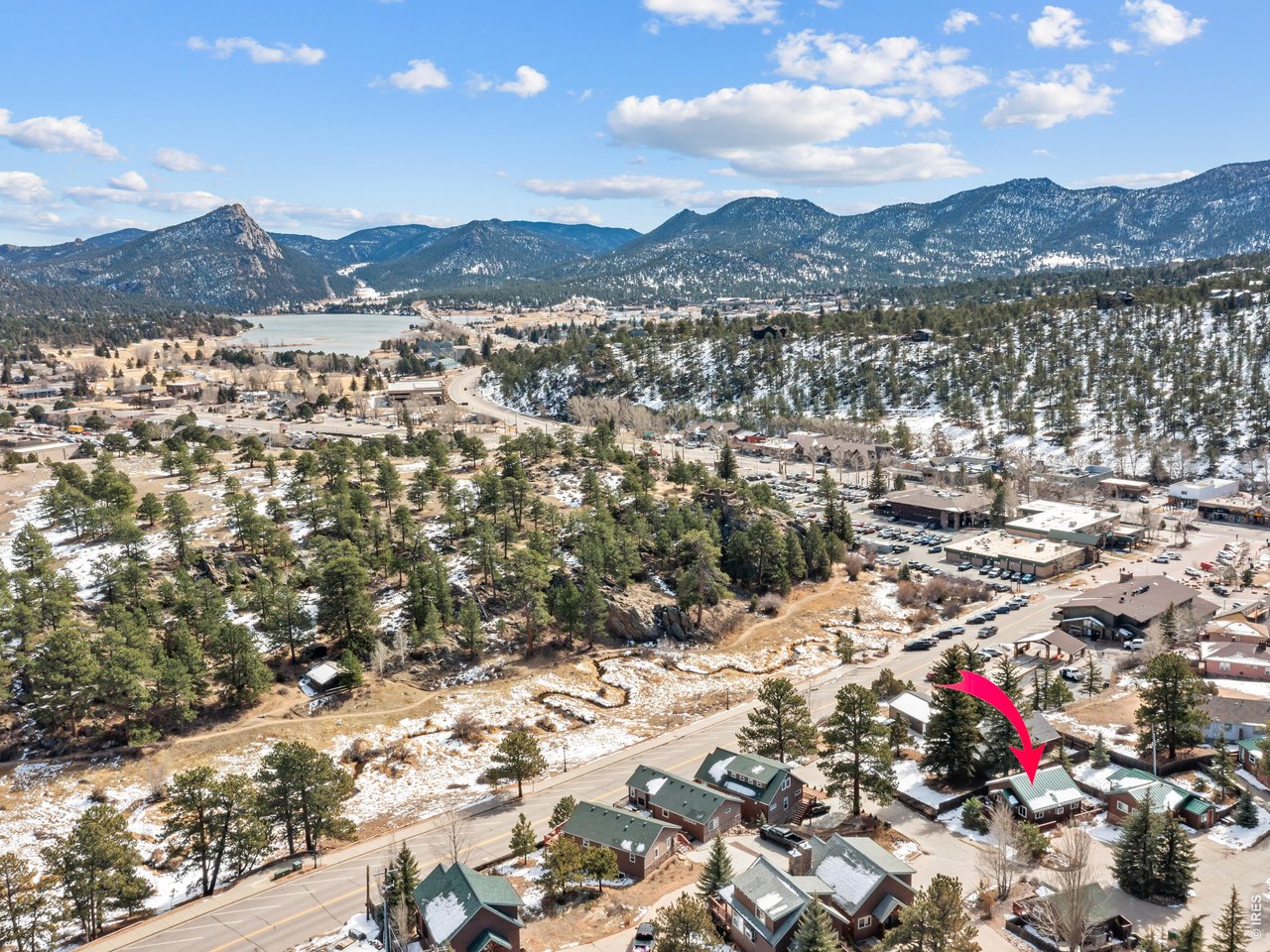 A rare opportunity: this one-bedroom, one-bathroom log cabin comes with a transferable short-term rental license, sold fully furnished and turnkey - ready to generate income from day one. Tucked a short walk from downtown Estes Park, the cabin offers authentic mountain character throughout. Vaulted tongue-and-groove wood ceilings and log-frame furniture set the tone in the open living space, with a mini-split system keeping things comfortable year-round. The oversized bedroom includes a desk area, and a full kitchen and modern bathroom with in-unit laundry round out the interior. Outside, a covered front deck frames views of Lumpy Ridge, and a private, fenced back patio with a hot tub offers a quiet retreat after a day in town. This zero lot line condominium is a turnkey opportunity in one of Estes Park's most walkable locations - whether you're adding to a rental portfolio or looking for a mountain getaway with income potential built in.