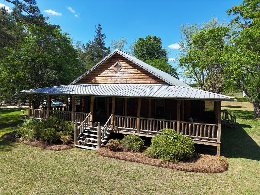Modern living meets RUSTIC CHARM! You have to see this amazing cabin on Oak Hill Rd. in Grady County. This 3BR/2Bath home has been beautifully renovated from top to bottom with gorgeous hardwood, high ceilings with exposed beams, and breathtaking southern touches. The living room is HUGE with a nice fireplace and lots of windows for pure South Georgia sunshine. There is a PERFECT kitchen with walk-in pantry, nice primary suite, wonderful bathrooms and bedrooms, and a small den ideally suited for a home office. There is no describing the amazing wrap-around porch – you simply have to experience it, with a glass of sweet tea, for yourself! All this on a picturesque 7-acre property, with outbuildings and separate shed that be used for a studio, office, artistic space, and MORE! Call your favorite agent TODAY for a closer look at this amazing property! Click here for virtual tour: https://my.matterport.com/show/?m=u6tfTTAHTmC&mls=1