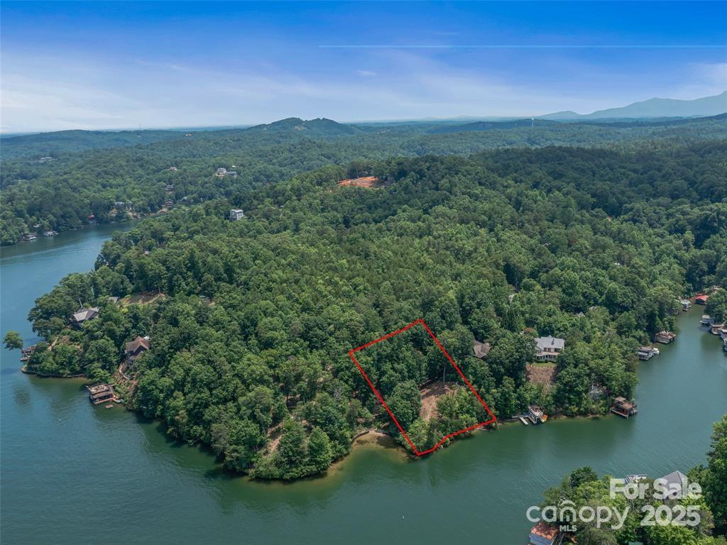 Here's your chance to own the best waterfront lot on Lake Lure—named Southern Living Magazine’s number one lake town! This lot, with 180 feet of shoreline, has a flat and very buildable perch on Snug Harbor Cove, overlooking perfect big water views and breathtaking vistas of Rumbling Bald and surrounding mountains. Sitting on more than an acre, the lot is private with a thick buffer of trees between the building site and the next lot. The lot is tap-ready to connect to the city sewer, you can avoid the limitations and cost of a septic system, and there are no HOA fees or restrictions on your custom build. The approach to the lot from the main road is very hospitable, private, and quiet. You couldn't be in a more convenient location on the south side of the lake, just minutes to the supermarket, public parks, and the most popular restaurants. Come see why National Geographic Magazine has called Lake Lure “one of the most beautiful man made lakes in the world."