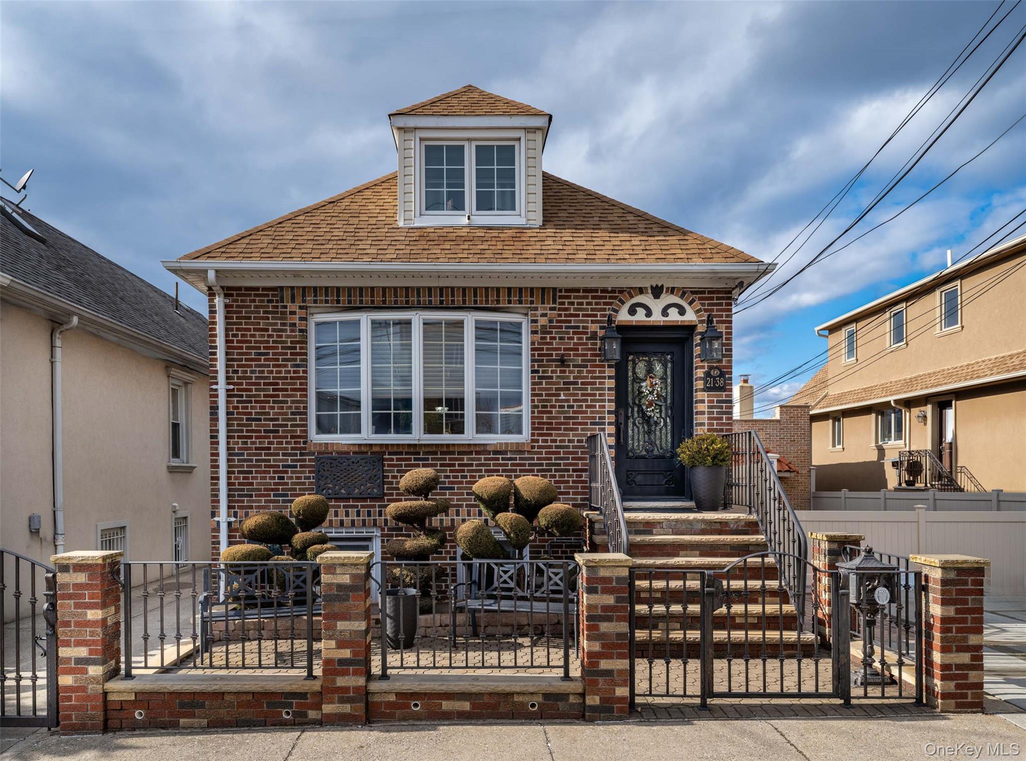 Set on an expansive 30 x 100 lot, this beautifully renovated single-family residence offers exceptional scale, refined finishes, and versatile living across multiple levels.The main floor unfolds into a gracious living and dining area finished in striking Jerusalem stone flooring, complemented by original plaster detailing and decorative molding that adds architectural depth. Just before the stairwell leading upstairs, a generously sized coat closet is conveniently positioned.The eat-in kitchen, renovated one year ago, is finished with granite flooring and appointed with GE Café stainless steel appliances, a double-door refrigerator, dishwasher, quartz countertops, and a fully vented hood. Two well-proportioned bedrooms are located on this level, along with a full bathroom finished in marble tile.Upstairs, two additional bedrooms are complemented by a full bathroom and a comfortable sitting area, creating a private upper-level retreat ideal for a den, office, or additional lounge space.The fully finished lower level significantly expands the home’s functionality and features a second full kitchen, additional living areas, two full bathrooms, and a dedicated laundry space with two-year-old washer and dryer. With its thoughtful layout and substantial square footage, this level offers exceptional flexibility for extended living, guests, or multi-generational use.Heating is supplied by a two-year-old gas steam boiler, while Fujitsu ductless systems provide heating and cooling on the first floor and cooling upstairs. Anderson windows are installed throughout the home.The outdoor setting is equally impressive. Cambridge pavers, a Trex deck, and two SunSetter awnings create layered outdoor living areas anchored by a fully built outdoor kitchen complete with granite countertops, sink, built-in gas barbecue, and authentic Forno pizza oven. Natural gas lines extend outdoors and into the 1.5 car garage.From the professionally landscaped front yard with wrought iron fencing and custom entry door to the seamless blend of Jerusalem stone, marble, and granite finishes throughout, this is a substantial and thoughtfully upgraded single-family home offering both elegance and flexibility.