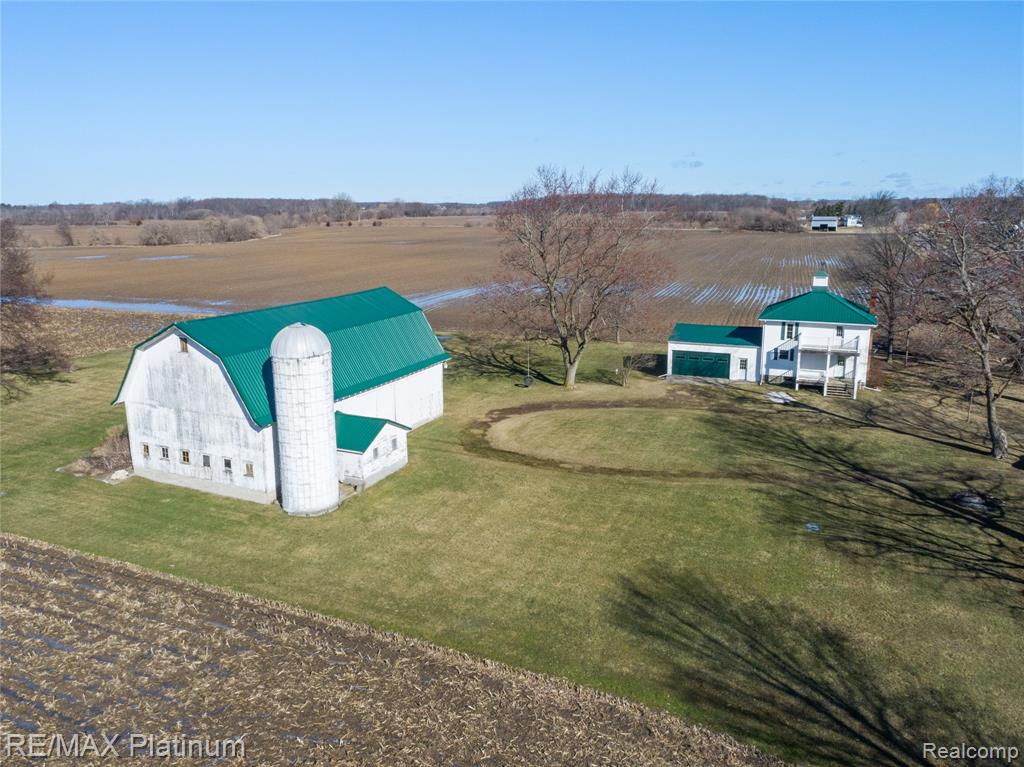 Charming farmhouse set on a picturesque 80-acre parcel featuring a mix of tillable land, wooded acreage, and a peaceful creek winding through the property. This 4-bedroom home offers timeless character and a spacious footprint, ready to be reimagined into something truly special! With solid bones and classic architectural appeal, this is the perfect opportunity for those with an HGTV vision.Recent exterior updates include 2023 metal roof, windows, and siding, and the property also features a barn with metal roof and additional outbuildings ideal for hobby farming, storage, or endless possibilities. Enjoy wide-open views and a serene country setting with expansive potential.Flexible acreage options available; contact listing agent for details. 63 acres tillable land, leased for the season. 14 acres of woods at back of parcel. Creek/Drain running through property. Home & Barn can be split off to +/- 3 acres if desired.