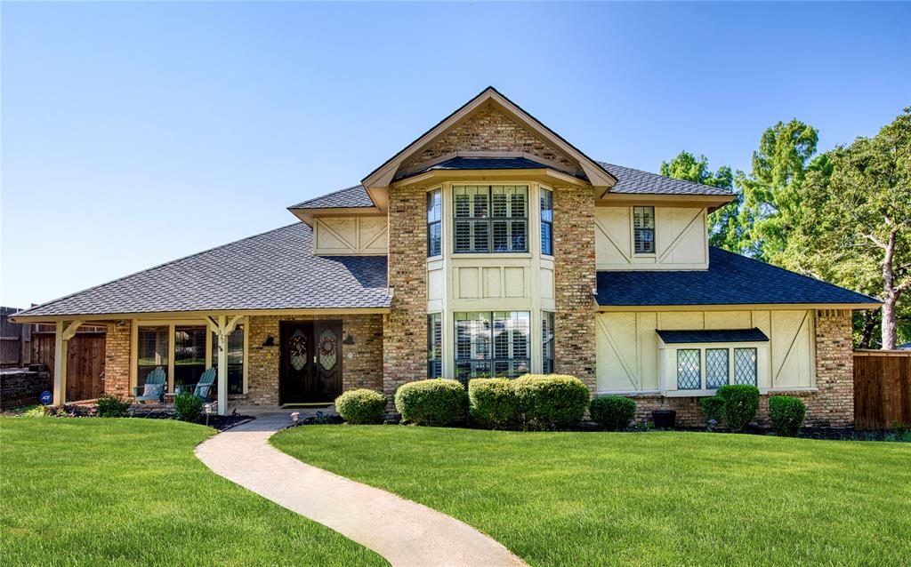 Tucked into the desirable Quail Crest Estates community in Bedford, this charming residence sits on an expansive quarter-acre cul-de-sac lot surrounded by mature trees & enhanced by a brick-bordered landscape. From the moment you arrive, you’ll be captivated by the picturesque front yard & the inviting front porch, perfect for sipping morning coffee or enjoying quiet evenings. Enter through double doors that open into a light-filled entryway with rich hardwood floors & plantation shutters. Inside, the spacious living room boasts a floor-to-ceiling fireplace & flows seamlessly into the kitchen & breakfast room. The impressive family room offers a vaulted ceiling with beams & rich wood paneling with two walls of built-ins, creating the perfect setting for relaxing or entertaining. Enjoy family dinners in the formal dining area with peaceful views of the front yard. 
The kitchen features granite, a central island, warm wood cabinetry, built-in desk, & cozy breakfast room that overlooks the serene backyard.  
The functional layout includes a downstairs secondary bedroom & a private upstairs primary suite, complete with a wall of windows, spacious en-suite bath with dual vanities, garden tub, separate shower, & generous walk-in closet. Two additional upstairs bedrooms share a full bath with dual sinks.
Step outside to enjoy the lush backyard retreat, framed by a privacy fence and mature trees. A flagstone patio provides the ideal space for entertaining, with large side yards and plenty of room for a future pool. Additional features include gated access to a path leading directly to the nearby elementary school, a 2024 roof, and no HOA. Living in Quail Crest Estates means enjoying peaceful tree-lined streets, friendly neighbors, & a location that blends tranquility with convenience, Just moments from shopping, dining, and top-rated schools. Search address in YouTube for video.