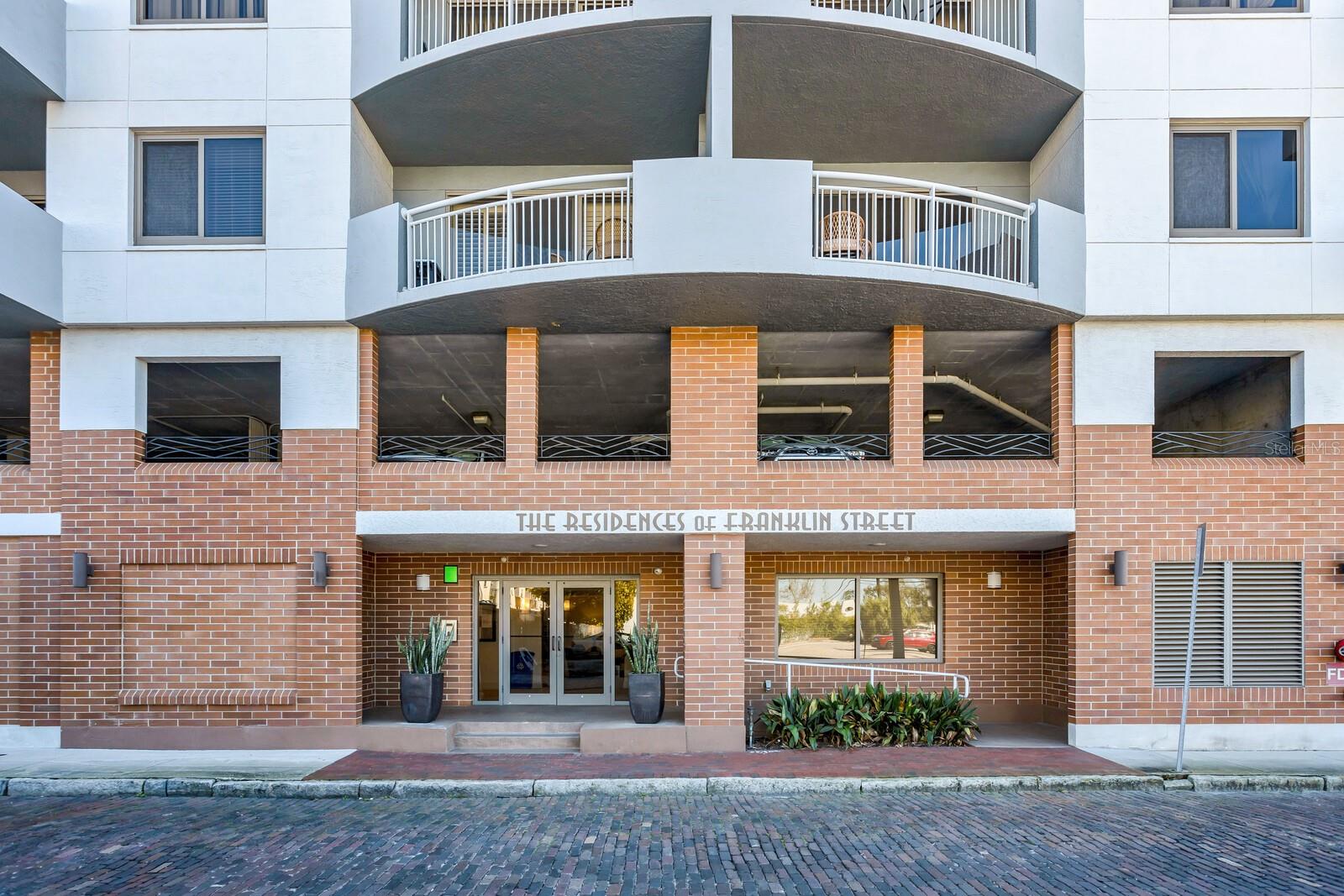 Welcome to The Residences of Franklin Street - considered one of the special gems of downtown Tampa.  TTHIS UNIT HAS BEEN REFRESHED AND REPRICED!    Experience contemporary urban living in this beautifully maintained residence with a thoughtful open floor plan and refined finishes throughout. Hardwood bamboo flooring flows through the main living areas, complemented by neutral tones and abundant natural light. The kitchen features granite counters, stainless steel appliances including a French door refrigerator, a Sub-Zero wine fridge with 78-bottle capacity, and a convenient breakfast bar—perfect for casual dining or entertaining.  A sizeable foyer welcomes you into the home, where you will also find a tasteful powder room with a custom vanity and mosaic tile accent wall. The spacious living and dining areas open to a balcony with north and east views, creating an inviting space for gatherings. An office nook and in-unit laundry add to the home’s functionality.  The owners’ suite provides a serene retreat with a private east-facing balcony, blackout window treatments, and an expansive walk-in closet. The primary bath features a marble double vanity, deep soaking tub, a walk-in shower tiled to the ceiling, and a separate WC.  The large secondary bedroom offers an ensuite bath, linen closet, and balcony access.  This gently lived-in home has been lovingly maintained by its original owners. Two premium parking spaces and a storage unit are included.  Residents enjoy a newly renovated lobby, secure building access, and a full suite of amenities: an 8th-floor fitness center, rooftop pool and lounge area, and a welcoming community room with floor-to-ceiling windows and a full kitchen.  Ideally located just a short distance from 3 Michelin-starred restaurants—Rocca, Ebbe, and Kosen—as well as the Arts District, Riverwalk, Straz Center, Tampa Museum of Art, Armature Works and so much more.  LOW HOA FEES; IN FACT, THE MONTHLY FEE DECREASED FROM 2025! Convenient guest parking is available on Franklin St (15-minute limit) and a nearby loading zone on Royal St offers up to one hour of free parking.