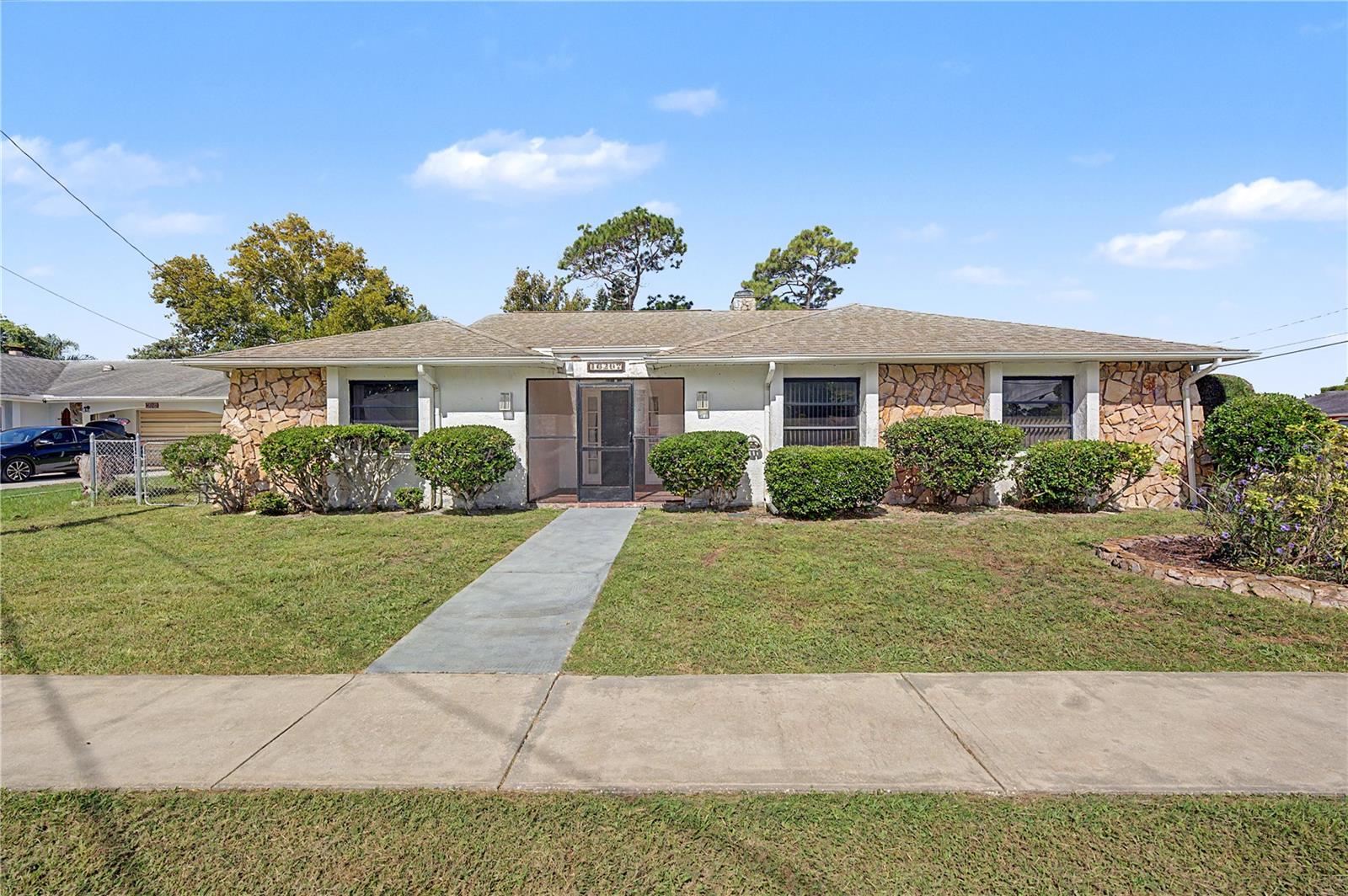 4 BEDROOMS + BONUS ROOM | SCREENED POOL | OVER 2,000 SQ FT | If you've been searching for a spacious pool home with room to make it your own, this is an opportunity you won't want to miss!  Situated on a nice-sized corner lot, this 4-bedroom, 2.5-bath home offers 2,080 square feet of living space plus a separate bonus room previously used as a home office.  The interior features generous living and dining areas, a wood-burning fireplace, built-in features, and a functional floor plan with plenty of space to spread out.  While the home retains much of its original character and is ready for cosmetic updates, it offers a solid foundation for a buyer looking to renovate at their own pace and create a space that reflects their own style.  The true highlight is the expansive outdoor living area featuring a private in-ground pool surrounded by a large screened enclosure with plenty of covered patio space for relaxing and entertaining.  The patio area is ready for outdoor grilling, with the potential for creating a great future outdoor kitchen.  Beyond the screened pool area is a fenced backyard offering additional outdoor space and privacy.  Additional features include an interior utility room with washer and dryer, utility sink and half bath, an approximately 1.5-car attached garage with additional storage space, a 2014 roof, and an A/C system replaced in 2021.  Located in a quiet Hudson neighborhood near US-19 with convenient access to shopping, restaurants, commuter routes and everyday necessities.  With four bedrooms, a bonus room, more than 2,000 square feet and a screened pool, this home offers a lot of space and potential at a price point that's increasingly hard to find.  Schedule your private showing today!