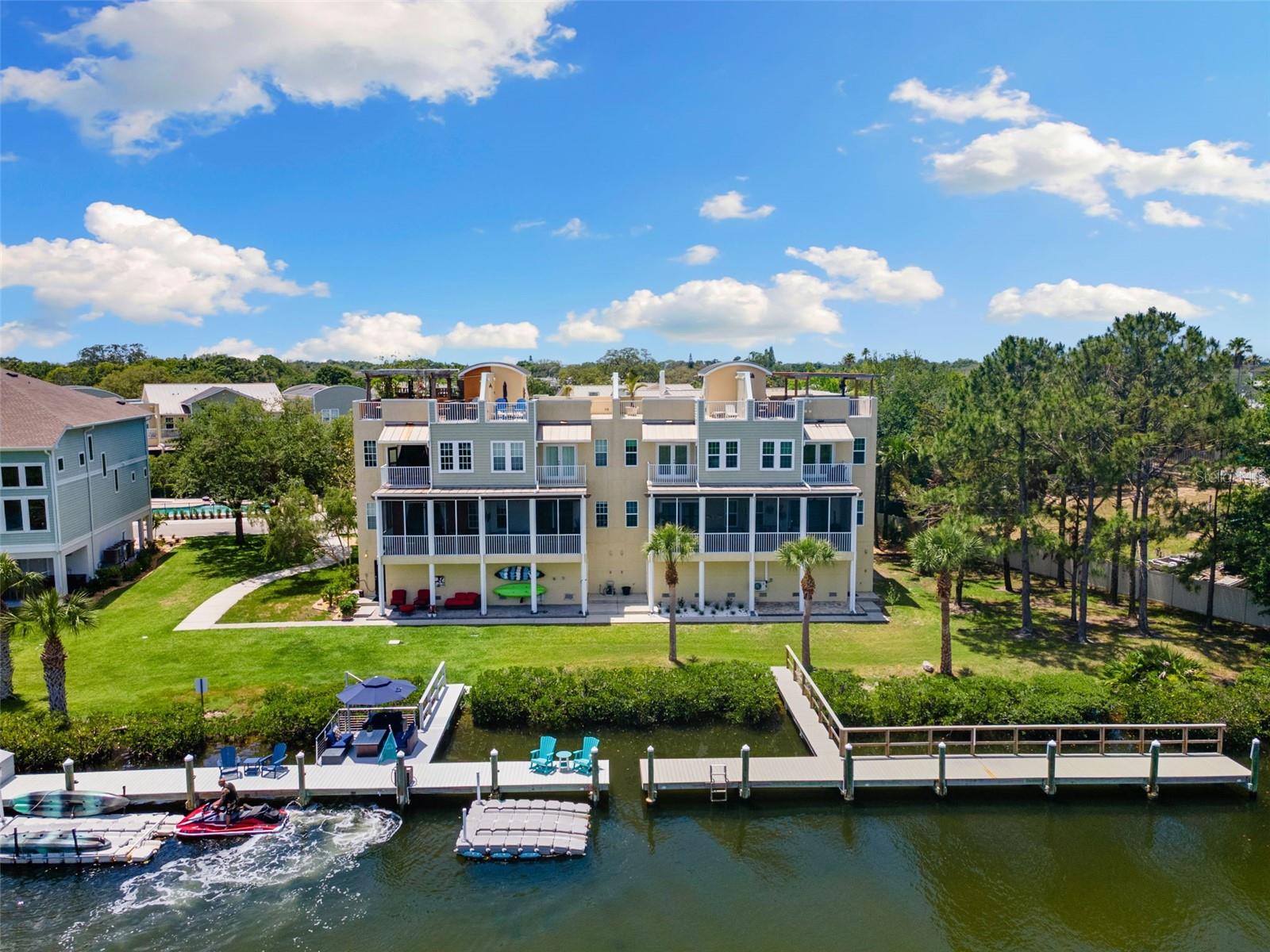 Experience luxury waterfront living like never before in this exquisite European-inspired townhome with breathtaking water views and custom features throughout. Designed for entertaining, the expansive rooftop terrace, made from Trex composite decking, boasts a Fire Magic BBQ system and outdoor kitchen complete with hot and cold water, multiple spacious sitting areas, divided by iron gates, a pergola wired for electric, irrigation for lush landscaping, and a custom gated entrance. Relax under the stars or host unforgettable gatherings while taking in endless views of the Anclote River and bird preserve. Inside, elegant detailing is found at every turn. The chef’s kitchen is a dream, featuring custom cabinetry with braided trim and florette detailing, granite countertops and island, a travertine and glass backsplash, newer stainless-steel appliances and Italian-designed, gas range, a wine refrigerator, and a wrap-around breakfast bar highlighted by Murano glass pendant lights. The spacious living area offers sweeping water views, crown molding, a custom gas fireplace with ornate mantle, and a built-in entertainment center and wine/liquor bar, perfect for evenings spent entertaining. The luxurious primary suite invites you to unwind with a custom California, walk-in closet, propane-gas fireplace and decorative mantel, custom lighting, plantation shutters, and surround sound. Soak in the garden tub while gazing up at the luxurious chandelier. Open the French doors to a private, covered balcony and enjoy your morning coffee overlooking the water and preserve, where you can watch wildlife in their natural habitat. Soak in the garden tub while gazing up at the luxurious chandelier. Additional bedrooms are designed with custom built-in desks and furniture, beds, and storage to maximize comfort and style. A private elevator, adorned with mirrors and hand-painted murals, provides easy access to all levels, blending convenience with artistry. Custom window treatments, faux-finished walls, and unique exposed brick accents add warmth and charm to every room. The oversized garage accommodates four cars plus a golf cart and opens to a covered, pavered patio wired for fans — the perfect spot to relax after a day on the water. Boaters will fall in love with the 48-foot dock made from Tex composite decking, complete with solar lighting and security cameras, a dock box, seating area with patio set and fire pit, reclaimed water hookup, custom railing, and a floating dock ideal for kayaks or jet skis. Small boats are welcome, and you’ll enjoy direct access to the Gulf for endless adventures. Low HOA dues include a beautiful community pool, making this exceptional townhome even more desirable. With too many custom features to list, this one-of-a-kind waterfront retreat is the epitome of Florida luxury. ***BRAND NEW ROOF JUST INSTALLED- Clean 4-Point and Wind Mitigation in attachments***