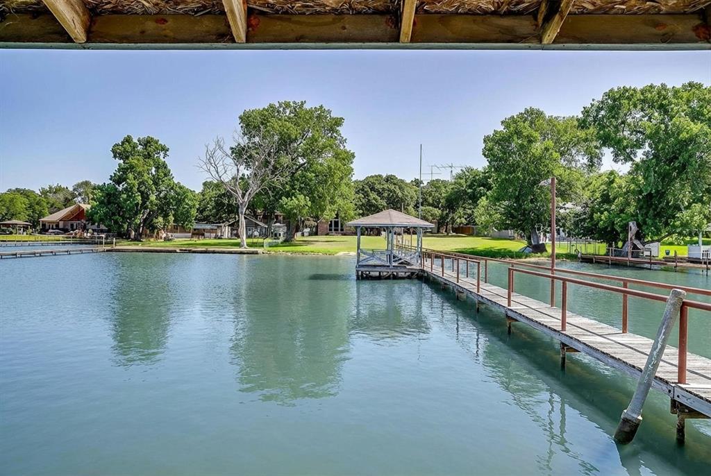 Eagle Mountain lake living at it's finest! Open water location near Lakeview & West Bay marinas. New Eagle MountainHigh school district. Around the corner from Eagle Mountain Park. Eagle Mountain lake features 4 boat up restaurants,5 marinas, Twin Points resort, & the prestigious Fort Worth Boat Club. 53 feet of waterfront provides great lake access.Boat ramp & boat dock with gazebo, covered platform, & open fishing area. Half acre lot with mature shade trees.Plenty of room for a pool. Main house includes 3 bedrooms & 1.5 baths. Huge open living area with vaulted ceiling &massive windows overlooking the water. Spacious kitchen with built in microwave, oven, cook top, & dishwasher. Separate laundry room. One bedroom downstairs. Oversized loft, half bath, & separate bedroom upstairs provide plentyof room for the family. 2 car side entry garage plus carport. Guest quarters with large kitchen, open floor plan, & wooddeck. One car garage with workshop space under apartment. OUTSIDE City limits allows for less property tax dollars.Separate well house. Sprinkler system plumbed to pump out of the lake.