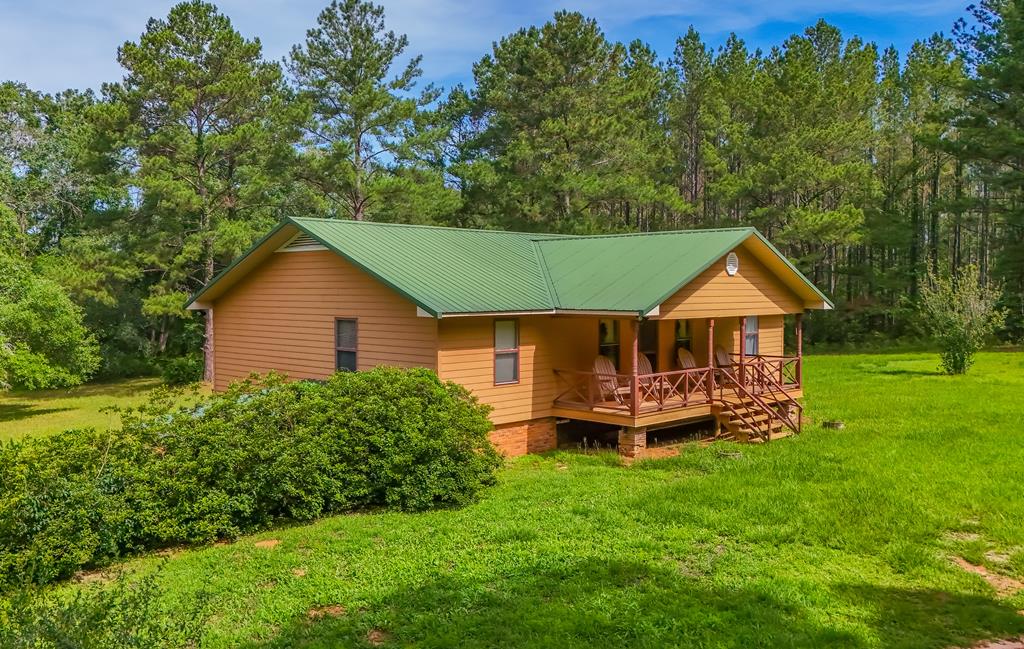 This magnificent, landscaped ranch offers the tranquility of country living with modern amenities, situated on nearly 10 acres in the picturesque community of Boston, Georgia. The property features a two-bedroom, two-bathroom split-level farmhouse that provides both comfort and seclusion. Set well back from the road, the home ensures privacy and peace, with convenient parking available beneath the residence. Outdoor Features include a fully fenced homestead, making it ideal for those seeking security and space for animals. In addition, there is a separate fenced area with a four-stall barn, perfectly suited for livestock or chickens, making this home a wonderful option for hobby farmers or those looking to enjoy rural life.   The home's interior boasts modern finishes, including granite countertops that add a touch of elegance to the kitchen. A no-show fingerprint refrigerator offers a sleek, clean look, while a gas stove and hot water heater deliver efficient, reliable performance. The home also includes a fairly new HVAC system, ensuring year-round comfort.