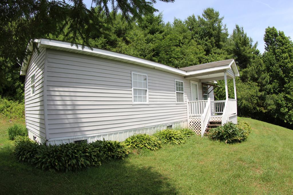 This charming singlewide home with a addition, nestled on 1.53 acres of level-to-rolling land in the scenic Meadows of Dan, Virginia area. Offering a peaceful country setting with convenient access to nearby amenities, this property combines comfort, simplicity, and location. The home features approximately 720 heated square feet with a practical main-level layout including a kitchen, dining room and living room combination, two bedrooms, a laundry room, and a full bathroom.  The property includes two detached storage buildings, providing valuable additional space for tools, outdoor equipment, storage, or hobbies. One building measures 8' x 10' and the second measures 8' x 12'. The surrounding 1.53 acres offer a peaceful setting with level-to-rolling terrain, giving you room to enjoy the outdoors, garden, or simply relax in the quiet countryside.  Conveniently located just 5 minutes from Meadows of Dan, VA and the scenic Blue Ridge Parkway, this property is also approximately 15 minutes from Old Mill Golf Course, 20 minutes from Stuart, VA, 30 minutes from Hillsville, VA and Interstate I-77, and 30 minutes from Floyd, VA.  Whether you are looking for a full-time residence, weekend getaway, or a peaceful retreat, this property offers an affordable opportunity to enjoy the natural beauty and convenience of Southwest Virginia living.