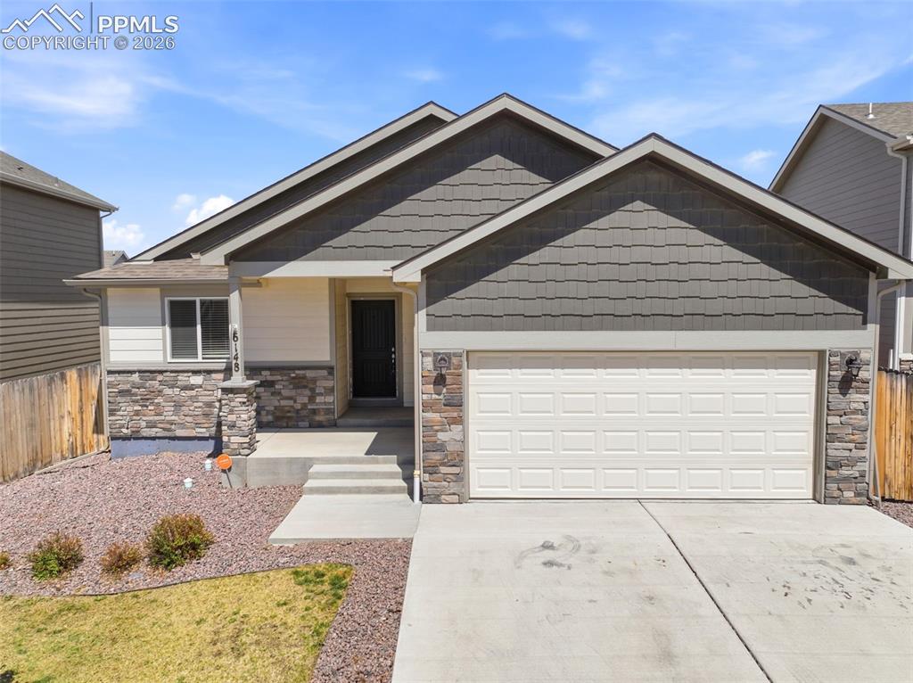 Welcome home to the popular Lowell ranch floor plan, offering thoughtfully designed living space, including 4 bedrooms, 3 full bathrooms, and a large finished basement. The main level features an open-concept layout with vaulted ceilings spanning the great room, kitchen, and dining area—creating a bright and spacious feel throughout. An electric fireplace anchors the main living room, creating a warm and inviting focal point. Hardwood flooring enhances the kitchen and dining areas, while the kitchen is beautifully appointed with stainless steel appliances, granite countertops, a center island, 42” upper cabinets with crown molding, recessed lighting, and upgraded finishes that blend style with functionality. The vaulted primary suite offers a relaxing retreat with a five-piece bath. Ceramic tile flooring extends through all bathrooms and the laundry room, and all bath and shower surrounds are finished in tile—no plastic inserts. Lighted ceiling fans in the great room and primary bedroom, upgraded trim with detailed windowsills, lever door handles, and Decora light switches add both comfort and sophistication. Central A/C ensures year-round comfort. Downstairs, the spacious finished basement includes a large recreation room, two additional bedrooms, and a full bath—ideal for guests, multi-generational living, or flexible entertaining space. Main-level laundry adds everyday convenience. Additional upgrades include a water softener, water purifier, and newer roof for peace of mind. Enjoy beautiful mountain views and a convenient location near Powers Boulevard and all military bases making commuting a breeze. With hardwood kitchen and dining floors, granite counters, stainless steel appliances, 42” cabinetry, upgraded lighting and trim packages, and extensive tile work throughout, this home truly stands out. Quality craftsmanship and elevated finishes make this home a standout opportunity—schedule your showing today!
