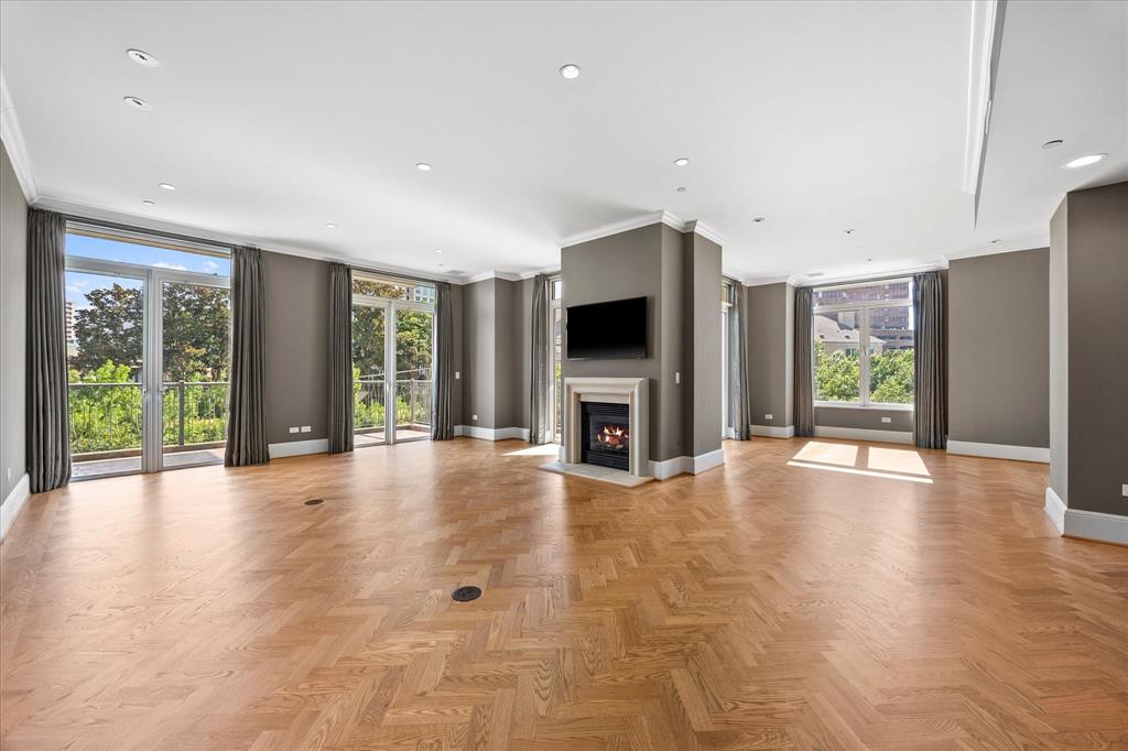 Set above the treetops of Turtle Creek Park, Residence 4E feels both connected to the city and quietly secluded within a sweeping canopy that stretches toward the Downtown Dallas skyline. Expansive windows fill the home with natural light, while four private balconies extend the living spaces outdoors and offer panoramic views of Downtown and the surrounding cityscape.Originally designed as a two-bedroom residence, the floor plan was opened to create a grand and exceptionally spacious one-bedroom home suited for both entertaining and everyday living. Surrounded by treetop views, the primary suite features two ensuite green marble bathrooms, creating a private retreat with a sense of timeless elegance.Thoughtfully updated and carefully restored, the residence blends old-world character with modern comfort. Solid oak flooring extends throughout the home, with intricate herringbone patterns defining the main living spaces and kitchen as they flow around the central fireplace.With generous entertaining spaces, exceptional storage, and a remarkable connection to its surroundings, Residence 4E offers something increasingly rare: the craftsmanship and charm of a landmark Dallas residence, thoughtfully reimagined for modern life.