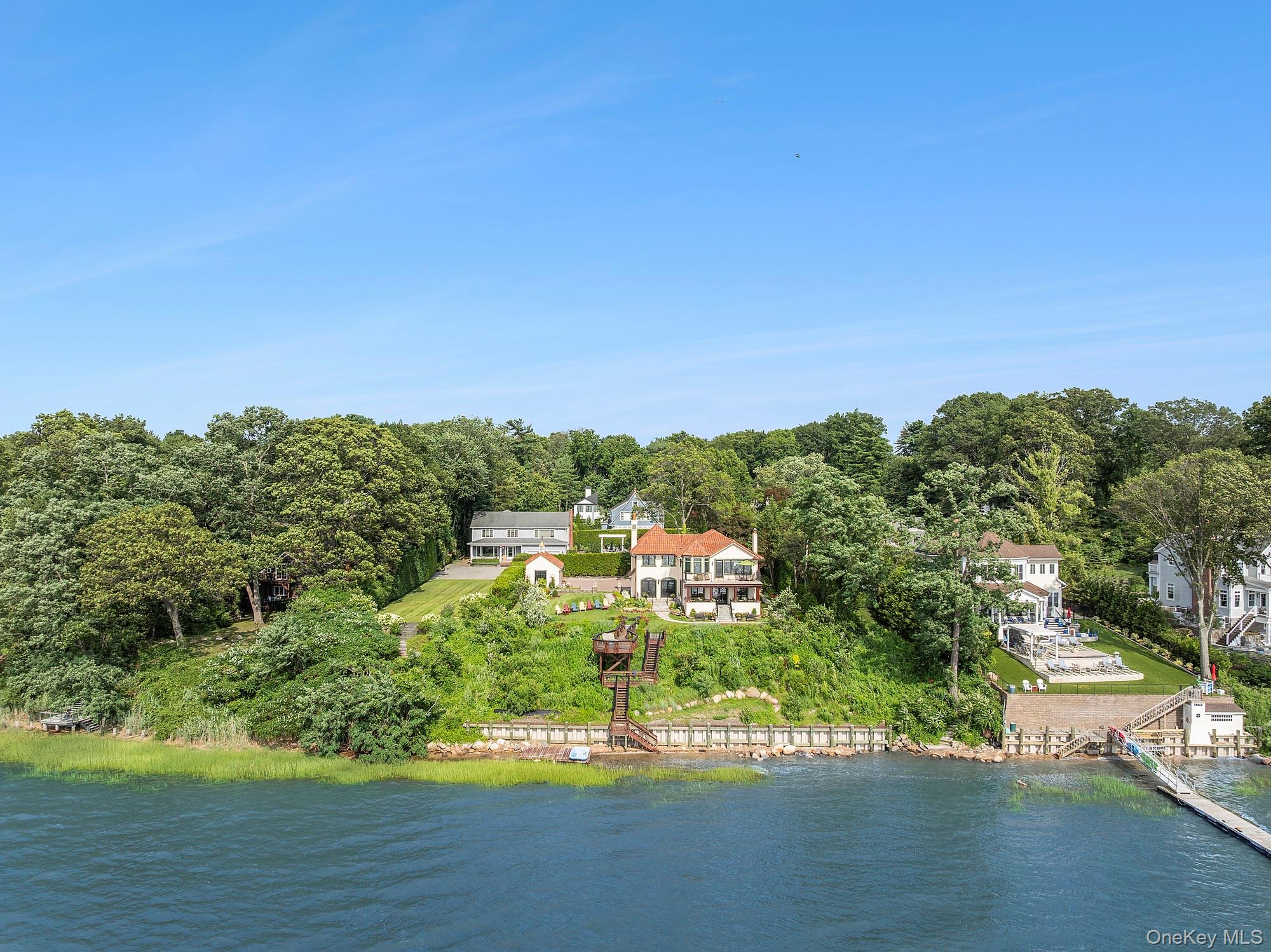Immerse yourself in this stunning waterfront villa on Centre Island. Although newly rebuilt inside and out, the original character of this 1929 colonial creates an amazing synergy between modernity and history. Perched comfortably above the bay, the backyard slopes gracefully towards the water's edge with a new seawall. The professional landscape plan not only created beautiful grounds, but a number of entertaining and play areas, including a dining terrace with built-in barbeque/prep station.  On the eastern side of the home, you are met by a sizeable driveway and a separate two car garage. Upon entering the front door, a beautiful onyx kitchen welcomes you. The charming dining room anchored by its fireplace, French doors face west, allowing you to take in the spectacular views. The cozy living room and its complementary fireplace. Through large French doors is an inviting covered terrace, making it the perfect place to entertain guests, or for intimate moments looking at sunsets over the bay. In addition to the stairs, all floors are accessible via a new elevator. The grand master bedroom comes complete with two large fully outfitted closets and a spa quality bathroom with unparalleled water views from shower and tub. A private balcony off the master offers the perfect place to enjoy a sunset or morning coffee. There are two additional bedrooms, a marble bath, and a small office on the second floor.  

The perfect weekend getaway or main residence this Centre Island home offers a turnkey option for any waterfront buyer could want.  Truly A One-Of-A-Kind! Call For Details.