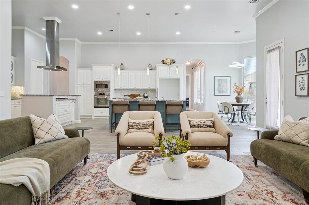 Perched gracefully atop a hill on a quiet corner leading into a cul-de-sac, this beautifully designed one-story home offers an open floor plan that seamlessly blends style, comfort, and function. With high ceilings and expansive windows throughout, natural light pours into every space, creating a bright and inviting atmosphere from the moment you arrive.
A welcoming entry opens to a private office and a spacious formal living or dining room, complete with a built-in bar and picture windows framing serene backyard views. The heart of the home is a freshly reimagined kitchen showcasing a double island layout, new countertops, cabinetry, paint, and modern appliances. It flows effortlessly into a cozy breakfast nook and an airy living room anchored by a sleek linear fireplace. Just beyond, enjoy seamless indoor-outdoor living on the oversized covered patio—perfect for entertaining or quiet evenings.
A separate bonus room just off the main living area provides flexible space for a media room, playroom, or home gym.
The split floor plan offers exceptional privacy. The primary suite is a private retreat, featuring a spa-like en suite with dual vanities, two walk-in closets, a soaking tub, and a walk-in shower. A spacious second primary suite with its own private bath is ideal for multi-generational living or long-term guests. Two additional guest bedrooms share a Jack and Jill bath, offering both comfort and convenience.
One of this home’s standout features is the four-car garage, offering abundant parking and storage. A rear garage door opens to the backyard, providing easy access for storing lawn equipment, recreational gear, or creating a flexible workshop space—a rare and valuable bonus for both everyday living and entertaining.