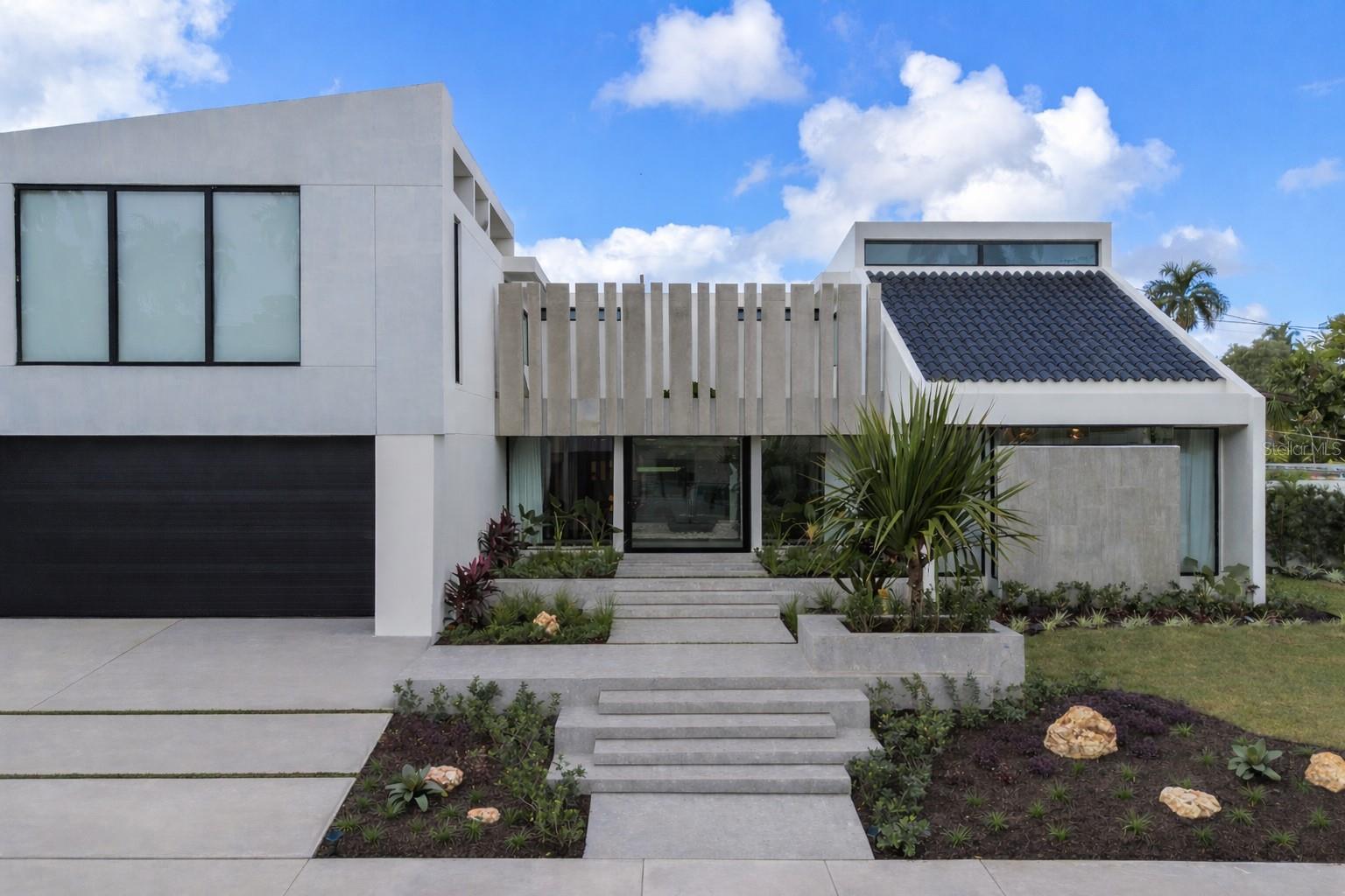 Welcome to a one-of-a-kind, fully remodeled luxury residence designed for modern living, comfort, and effortless entertaining. Located in the highly sought-after community of Extensión Santa María, this architectural home blends sleek contemporary design with warmth, functionality, and smart technology.From the moment you arrive, the striking façade and tropical landscaping create a powerful first impression. Inside, a dramatic glass-enclosed foyer with a tranquil indoor garden welcomes you with natural light and a sense of calm that sets the tone for the entire home.At the heart of the property is a stunning Italian-designed kitchen by Formato, featuring quartz countertops, sleek black cabinetry, and high-end stainless steel appliances. The kitchen seamlessly connects to a stylish wine and bar area with outdoor access—perfect for entertaining and everyday enjoyment.The home offers 6 spacious bedrooms, including a versatile downstairs suite with private bathroom ideal for guests, a gym, or home office. Upstairs, the oversized primary suite serves as a private retreat with a spa-inspired bathroom, elegant vanity area, expansive shower, and two custom walk-in closets designed for boutique-style organization.This smart home is equipped with architect-designed LED lighting, integrated sound system, new security windows, inverter air conditioning (3 central units + 7 mini-splits), a 24 kW backup generator, and a 1,200-gallon water cistern for peace of mind and efficiency.Outdoor living is just as impressive, featuring lush tropical landscaping, a fun upstairs terrace, parking for five vehicles, and a private convertible basketball/pickleball court—perfect for enjoying the Puerto Rico lifestyle year-round.This residence was thoughtfully designed for comfort, efficiency, and elevated living—a rare opportunity in San Juan.