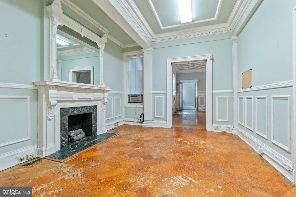 With ceilings soaring up to 13 feet and nearly 1,600 square feet of space, Unit 11 delivers the rare scale and grace of a Mount Vernon townhouse suite.This refined, executive-level condominium offers five rooms—three of them private—providing flexibility for professional or residential adaptation. Two decorative mantels, parquet wood floors, detailed picture rail moldings, and intricate trim add to its formality and charm. A full bath serves the suite, and a private internal staircase connects Unit 11 to Unit 1 below. Together, Units 1 and 11 provide over 3,500 sq. ft. of contiguous space, combining the presence of a parlor-level suite with the practicality of a lower-level entry. Ownership will make Unit 11 self-contained if contiguous space is not desired. Tall windows fill each room with natural light, highlighting the craftsmanship and proportions that define Mount Vernon architecture.  The history: At the heart of Mount Vernon, 1118 and 1120 Saint Paul Street embody Baltimore’s architectural legacy. Designed and once occupied by George A. Frederick — the young prodigy behind Baltimore City Hall and the city’s park system — these brownstones reflect both history and craftsmanship. Now ,for sale within them are five distinct condominium units: dramatic parlor-level suites with soaring ceilings and ornate detail, alongside expansive lower-level spaces with flexible layouts and private entries. Together, they offer owner-users a rare mix of historic pedigree and practical adaptability in Baltimore’s cultural core.