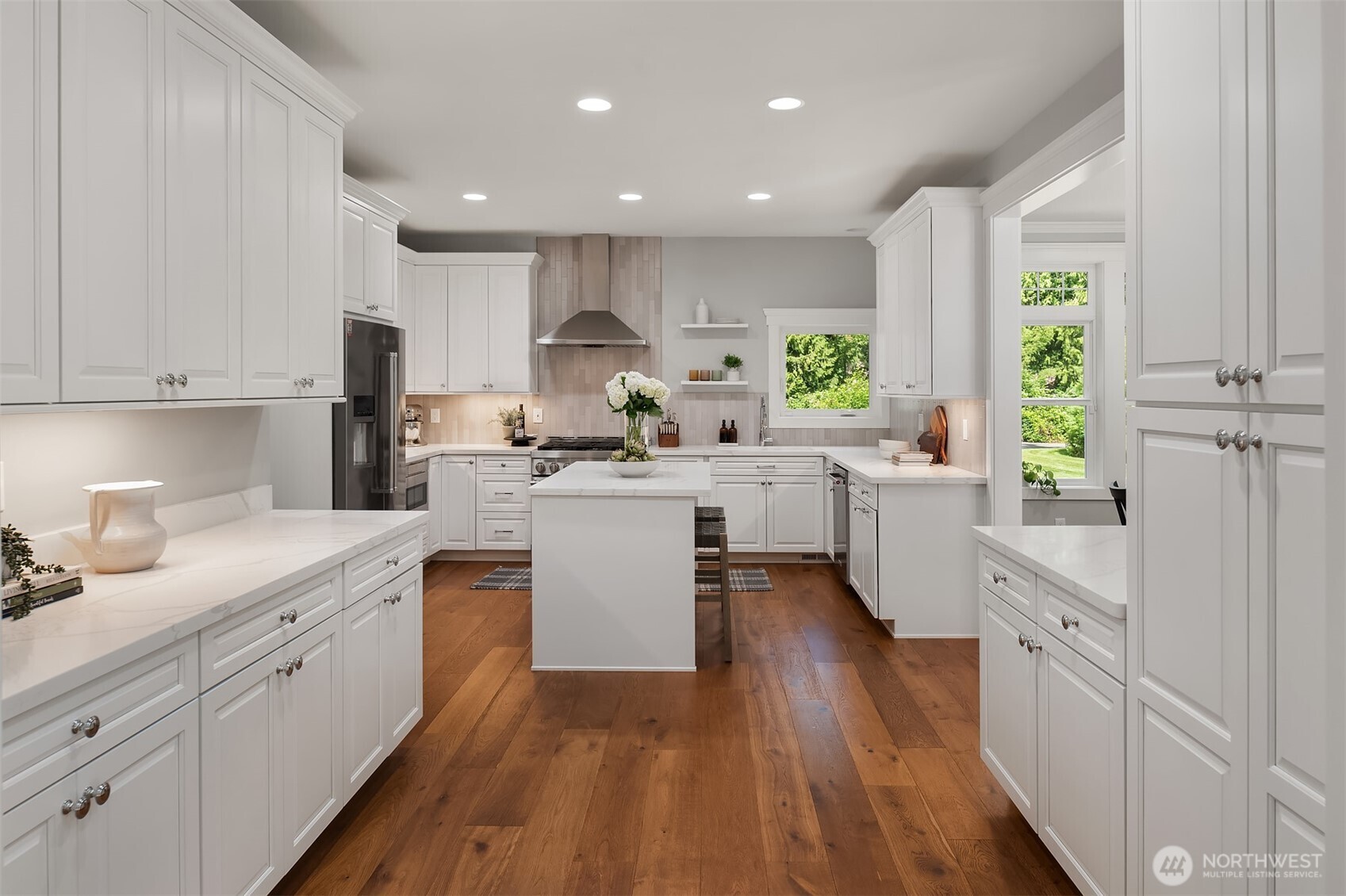 Updated chef's kitchen featuring quartz countertops, custom cabinetry, premium appliances, oversized island, and abundant prep space.