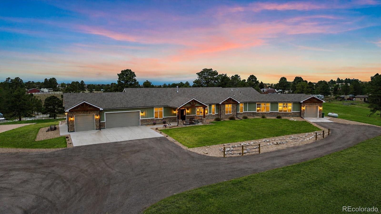 This home understood the assignment—luxury, multigen flexibility, & close-in acreage living without compromise. Set on 5+ stunning acres w/ panoramic Colorado views, this custom walkout ranch was intentionally designed for the way people live today—offering elevated entertaining spaces, private retreats, & a beautifully integrated in-law residence ideal for multigen living, long-term guests, or future income potential. Inside, soaring vaulted ceilings, rich hardwood flooring, & designer finishes create a warm & sophisticated atmosphere filled with natural light. At the center of the primary home, the chef’s kitchen is designed to gather—featuring a six-burner + griddle Thermador range w/ double ovens, pot filler, quartz island, custom cabinets, and a pass-through serving window. The great room is anchored by a stunning stone fireplace and connects to the covered deck through an oversized sliding door, creating the ultimate Colorado indoor-outdoor lifestyle experience. The main-level primary suite feels like a private retreat with a spa-inspired five-piece bath, soaking tub, and generous walk-in closet. Each secondary bedroom includes its own ensuite bath, offering comfort & privacy rarely found in today’s market. The finished walkout lower level expands the home’s versatility with two wired theater areas, wet bar with dishwasher, & abundant natural light. All main floor bathrooms feature heated floors. *This property features a fully appointed private multigenerational suite—complete with a primary bedroom, 3/4 bath, stunning quartz kitchen with stainless steel appliances, spacious great room with fireplace, stamped concrete patio, & attached single-car garage.*Outside, the property provides flat usable acreage ideal for horses, animals, future outbuildings, & recreation. Solar powered gate, covered outdoor living spaces, play areas, excellent WiFi, & an oversized 3-car garage complete this rare offering blending luxury, functionality, & Colorado lifestyle living.