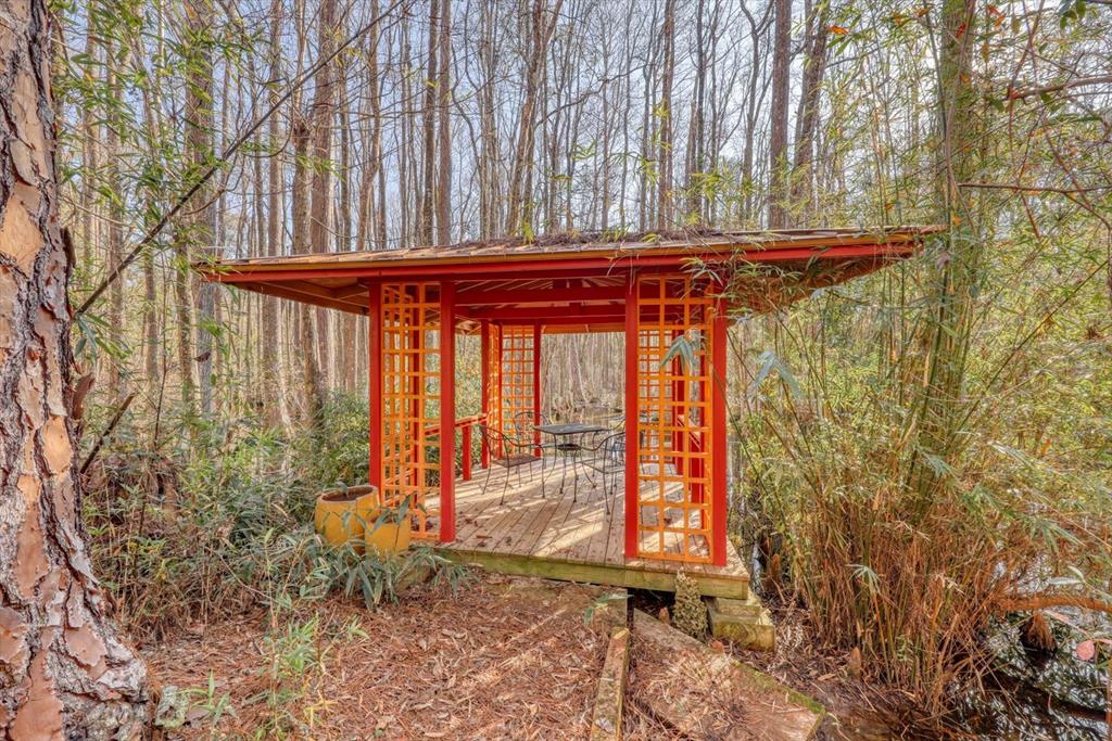 High-speed Internet is Available! You must LOVE THE OUTDOORS—this should be a state park. The property was well designed by the well-known artist Lawrence Tobe and his devoted family.  The home is 2400 SF with large screen porch, 4BR/3BA with a large primary suite.  The guest home has been an art studio with a kitchenette and full bath.  Miles of walking trails meander through hundreds of Camellias, azaleas, bamboo alleys, etc.  Many species of plants and trees are rare and not native to America.   The homes and gardens are approx 10 acres of the almost 100 Acre Farm.  The property also has abundant wildlife, including many species of birds, deer, etc.  Click the link for more photos and video:  https://floridavisualmarketing.com/901-Co-Rd-100