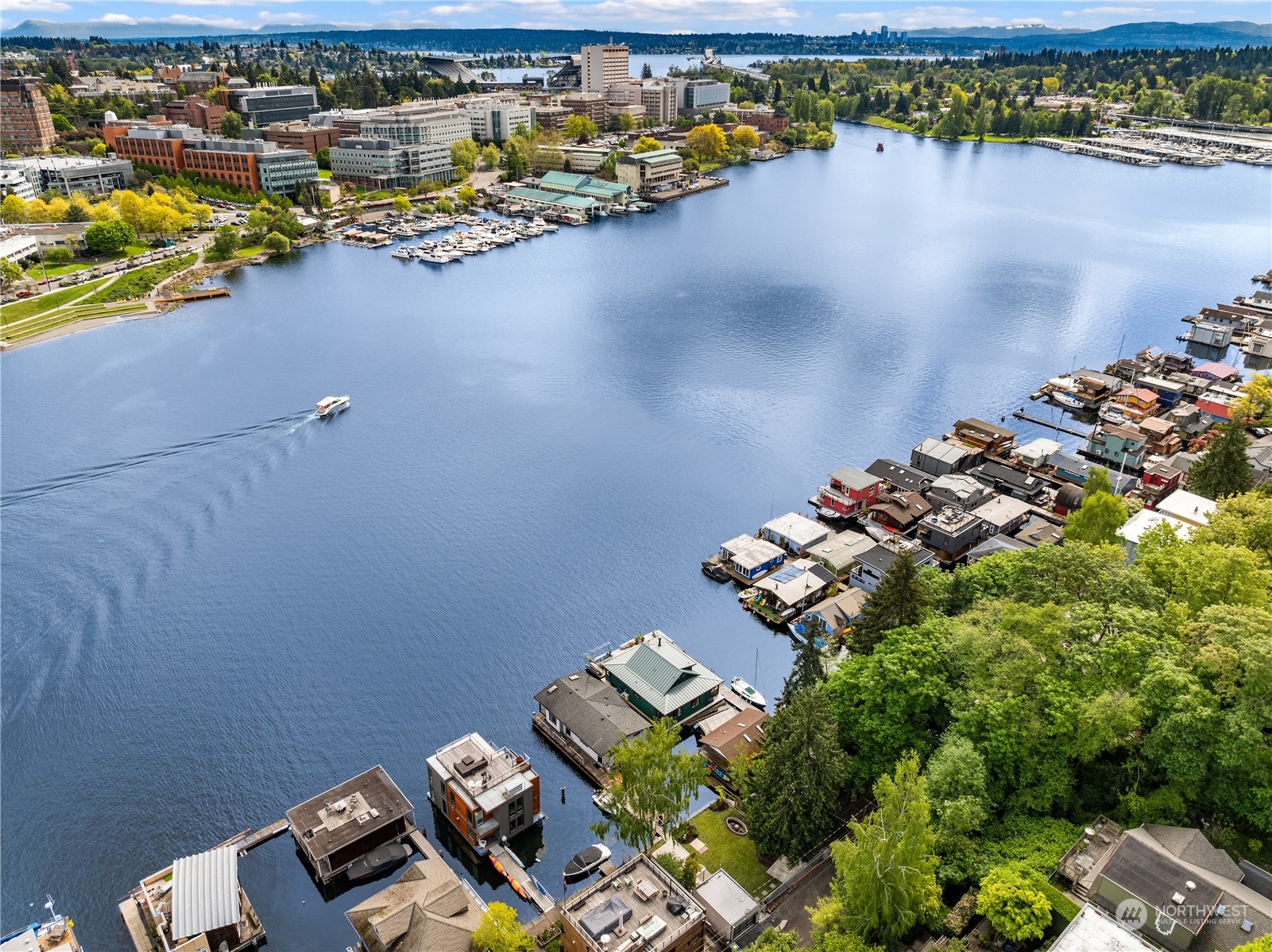 Portage Bay Beach Club // Discover this exceptional property nestled on the serene shores of Portage Bay, offering views of the iconic University Bridge and Seattle Yacht Club. At its heart lies a charming floating home with a thoughtfully designed 2BR, 2BA layout on a single level. The great room is framed by panoramic windows showcasing views of Portage Bay and the University of Washington. Immerse yourself in a private beach club ambiance, complete with 50' of low-bank bulkhead waterfront, 85' deep-water moorage, grandfathered over-water coverage, ample storage, and 3-car parking. Envision idyllic afternoons in your personal oasis or thrilling sailing excursions to the San Juan Islands. Surveys and development documents available.