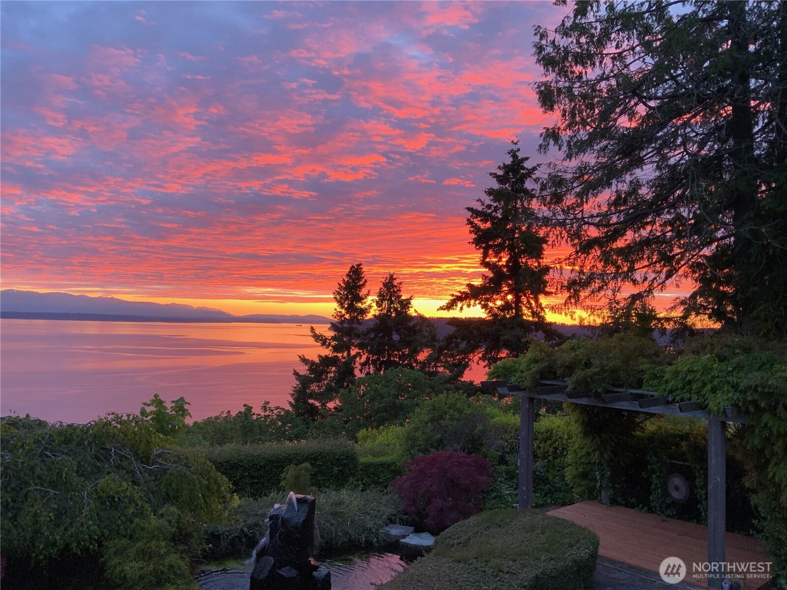 A rare offering in coveted Wind & Tide, this spectacular high-bluff residence captures sweeping panoramic views of Puget Sound and the Olympic Mountains from beautifully designed interiors and serene outdoor spaces. Inspired by the beauty of the Northwest coast and rooted in timeless Northwest architecture, the home blends dramatic design with warmth, comfort, and exceptional privacy. Rich textures and warm finishes—including slate floors, hardwoods, artisan ironwork—create interiors filled with depth, character, and understated sophistication. Walls of windows frame the ever-changing water and mountain vistas, bringing natural beauty into nearly every room and creating a seamless connection between indoors and out. The spacious primary suite is a peaceful sanctuary with its own private bath and calming outlooks, while the home’s overall design captures the essence of elevated Northwest living—comfortable, refined, and deeply connected to its extraordinary setting.Thoughtfully designed great room with casual living spaces offer an effortless flow for entertaining and everyday living, with inviting gathering areas that open to beautifully landscaped outdoor settings designed for quiet mornings, sunset evenings, and year-round enjoyment. Wonderfully private and surrounded by lush mature landscaping, the grounds evoke the tranquility of an exclusive coastal retreat.Unforgettable in both atmosphere and location, this is a home designed for those who truly love where they live.