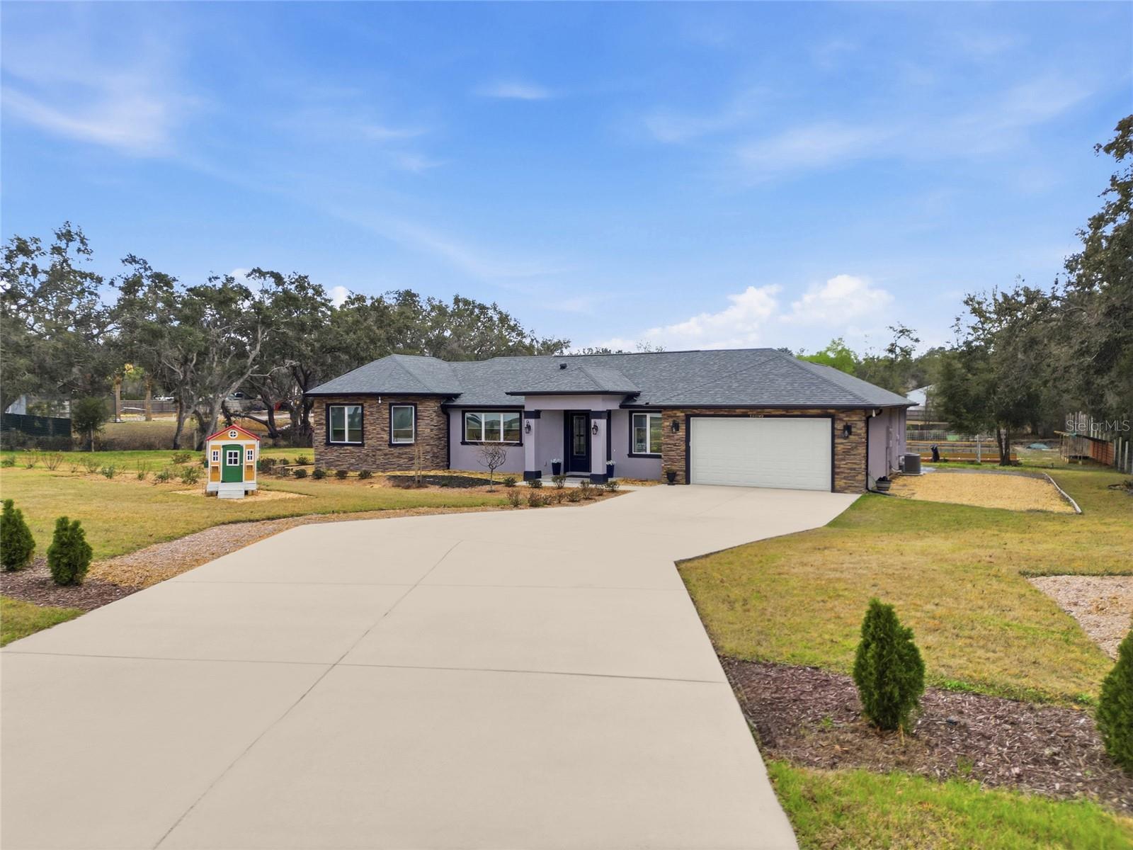 If you’ve been searching for space, privacy, and the ability to live more intentionally — without giving up modern luxury — this custom-built 2024 home on 1.1 fully fenced acres delivers.Built by Cobra Custom Builder, this 3-bedroom, 2-bath residence offers 2,622 sq ft of thoughtfully designed living space in Spring Hill’s AR1 agricultural zoning district, blending rural freedom with contemporary comfort — and no HOA.Inside, soaring 10-foot ceilings and professional-grade luxury vinyl plank flooring set the tone. The open-concept layout flows seamlessly into a chef-inspired kitchen featuring Diamond soft-close cabinetry, custom organizers, granite countertops, an oversized island with seating, organized cabinet pantry storage, and smart Wi-Fi connected appliances — all conveying.The private primary suite is thoughtfully designed with its own dedicated A/C zone for personalized comfort and includes a versatile bonus room ideal for a sitting area, reading retreat, extended walk-in closet, nursery, office, or dressing lounge. An additional shoe closet enhances storage and flexibility, allowing the space to adapt to your lifestyle needs. The  primary bath features a large walk-in shower with double rain shower fixtures, creating a true retreat experience.Smart-home features include electric shades throughout, smart thermostats, security system, exterior cameras, and number-code entry. Additional highlights include a finished 2-car garage (552 sq ft), expansive concrete driveway and patio areas, well and septic system.Step outside and experience what truly sets this property apart. The fully fenced backyard combines relaxation and self-sufficiency with a conveying hot tub, a 12x24 storage shed with reinforced flooring, irrigation shed, and a fully developed homestead farm representing approximately $25,000 in infrastructure. Enjoy a 75-ft grape trellis, 8 metal raised beds, 20 wood raised beds, cinder block potato bed, hot house trellis, grow trellis, two compost areas, 7-zone irrigation system, and an extensive collection of established fruit trees and berry bushes.Located approximately 4 miles from the Suncoast Parkway, 1.5 miles from Tampa General Hospital – Spring Hill, and about 45 minutes to Tampa and Tampa International Airport, this property offers peaceful acreage living with everyday conveniences just a short drive away.