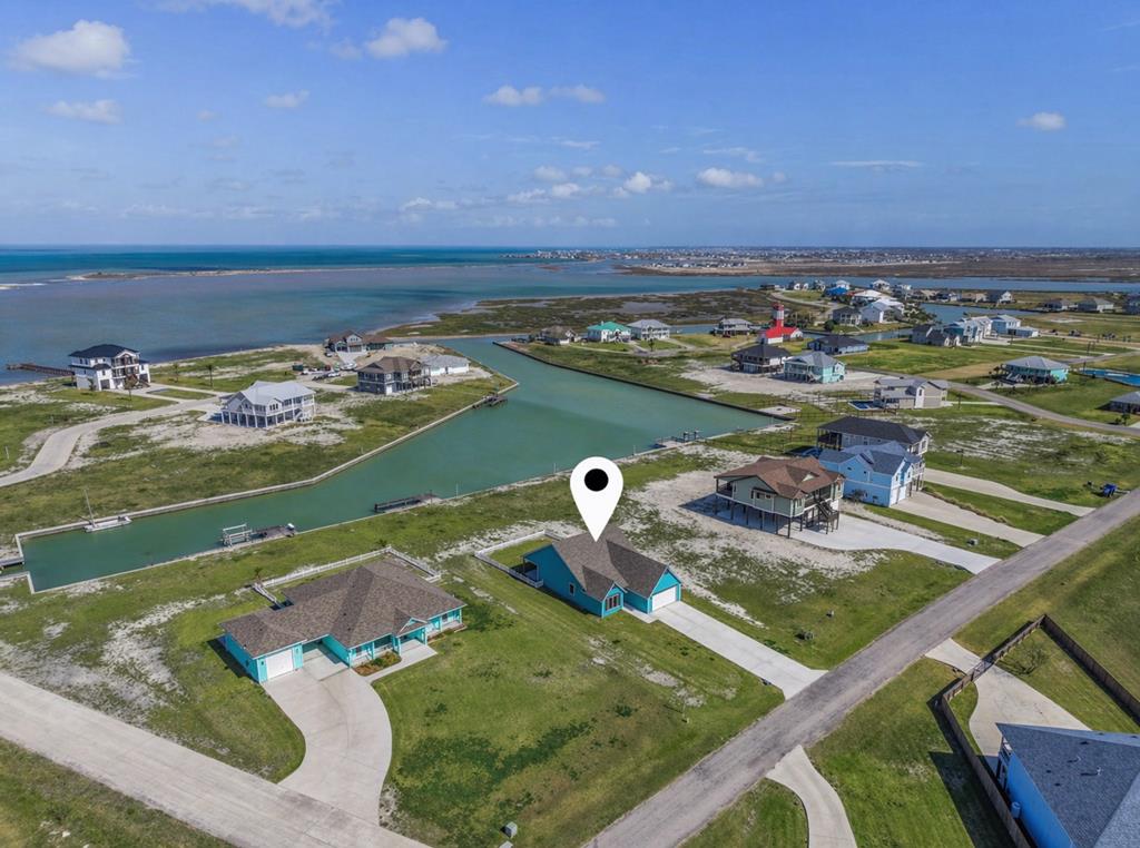 Custom built in 2024, 1515 Cape Velero offers refined waterfront living with direct canal access to Port Bay.  Situated on a generous 1/2 acre lot, this 3-bedroom, 2-bath home features an open floor plan with raised and tray ceilings, ceramic tile floors with a wood look, and expansive water views from the living, dining, kitchen, and primary suite - including views of Rattlesnake Point.  The kitchen is designed for both function and style with a large island, quartz countertops, walk-in pantry, and stainless appliances including an induction range, build-in microwave, dishwasher, and side-by-side refrigerator with ice and water.  The primary suite offers bay views, a walk-in closet, and a spa-inspired bath with dual vanities, soaking tub, and oversized tiled shower.  Additional features include foam insulation with attic dehumidifier, fiber internet, hurricane impact screens, reinforced garage door, finished 2-car garage with storage, large covered back porch, fenced yard, landscaped lawn with sprinkler system, and extra-large driveway.  Enjoy a horseshoe shaped boat pier with lighting, freshwater, future lift wiring, plus a private subdivision boat ramp.  Quiet neighborhood, minutes to downtown Rockport, Hwy 35, Port Aransas and Corpus Christi.  World-class fishing and coastal hunting - right out your back door.