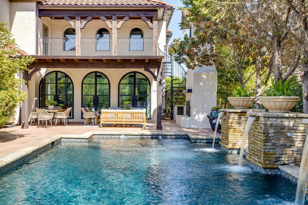 You will not believe the transformation! This just-renovated home sits on a 0.5-acre lot in prestigious Montserrat, complete with a resort-like backyard. Exquisitely remodeled in 2026 by Anchor Design, this completely transformed home is a showplace that blends tasteful design with established architecture. Classically Mediterranean details, incl wood corbels, tile roof, cast stone columns & multiple entrances, set the tone. You'll love the expansive pond view across the street & secluded backyard. Inside, thoughtful care went into reworking every space for clean, classic, timeless lines. The foyer unfolds immediately into a dramatic, winding stairwell. To the left, a beamed study with generous storage, color-drenched walls & its own separate entry. To the right, a flexible space perfect as a formal dining room or sitting room. The butler's pantry is enormous & beautiful, a space that invites you to linger with a beverage in hand. Step into the spacious living room & your eyes go straight to the four new, dramatic black modern arch doors lining what was once a patio. The kitchen is a chef's & designer's delight, with an etched marble countertop atop a simply stained wood island, a farm sink & state-of-the-art appliances. Down a long, private hall, the primary suite surprises at every turn. A sitting room with fireplace, private patio, & generous primary bath and closet. In all, the home offers 5 bedrooms, including 2 on the main level, 5 full baths, 2 half baths & a 4-car garage. Upstairs offers even more flex space, including a beautiful media room & a balcony overlooking the pool, connected by an outdoor spiral stairwell. Recent upgrades incl new HVAC systems & water heaters, plus the peace of mind of a tornado shelter & whole-home generator. The outdoor living is spectacular, with a heated, saltwater pool, dramatic water features, covered patio, outdoor kitchen & gas fireplace. Expansive green space & a basketball court complete this exceptional outdoor retreat.