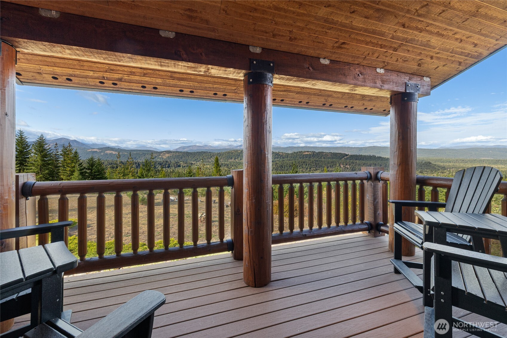 One of four porches thoughtfully positioned around the home, offering a covered outdoor space with sweeping views across the surrounding forest and mountains.