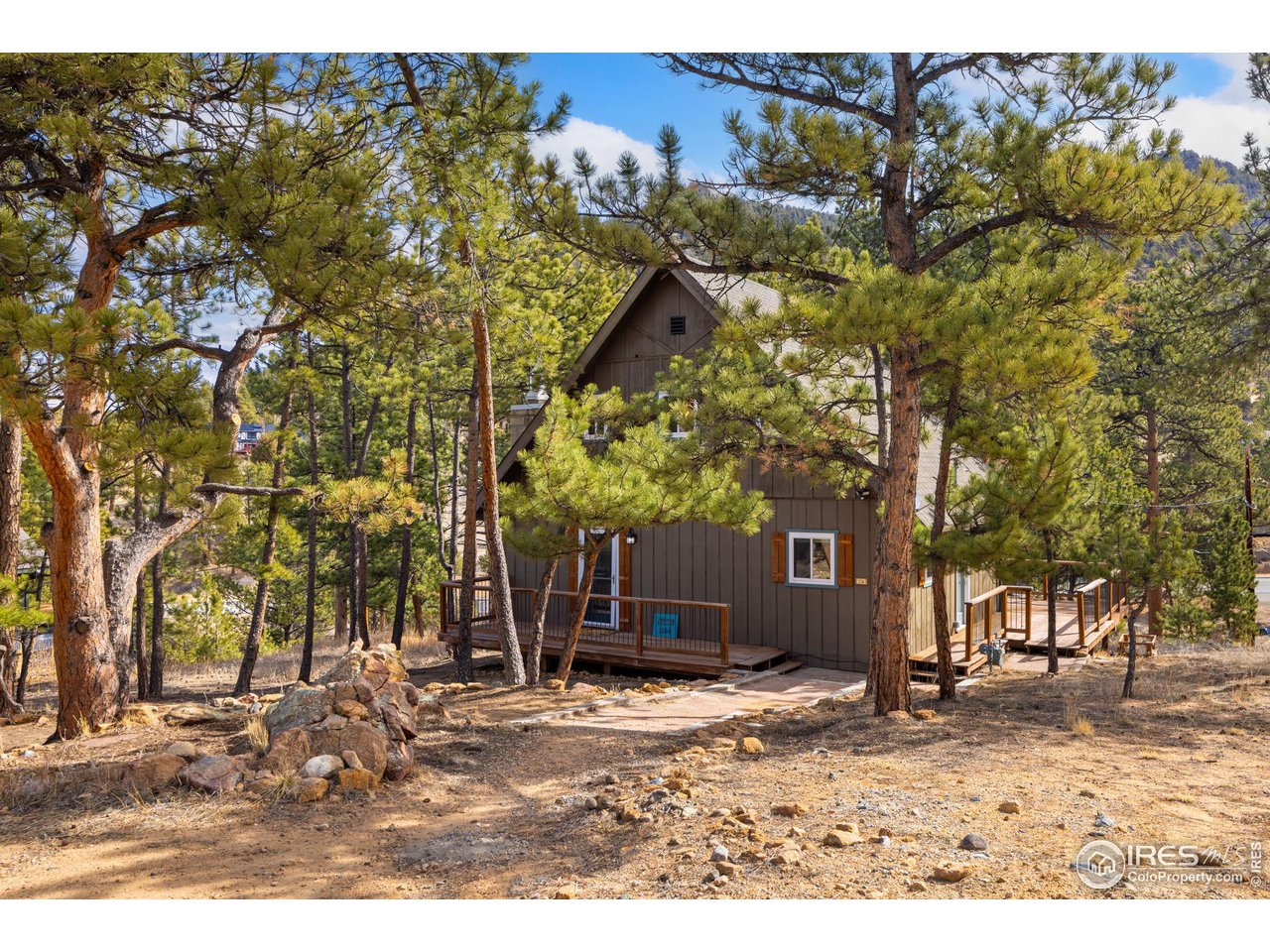 Discover this inviting 3-bedroom, 1.5-bathroom mountain cabin located on a peaceful cul-de-sac in Carriage Hills. Perfect as a full-time residence or mountain getaway, this home sits on a .4-acre wooded lot and offers the tranquil sound of Fish Creek from the spacious back deck. Inside, enjoy comfortable living space, updated in 2022, featuring an electric fireplace, updated flooring, and a warm blend of rustic charm and modern design. The light-filled living area creates a relaxing ambiance, ideal for quiet evenings. The well-appointed kitchen features custom cabinetry, black soapstone countertops, and stainless steel appliances, with direct access to an adjacent laundry area. Upstairs, two additional bedrooms offer flexible space for guests, an office, or creative studio use. Outdoor lovers will appreciate the home's proximity to trails leading to Lake Estes and its short drive to Rocky Mountain National Park. Enjoy easy access to shopping, dining, and year-round recreational opportunities. Additional features include plenty of off-street parking, a spacious deck, and a wooded setting that provides a sense of privacy and natural beauty. Don't miss the opportunity to make this charming Estes Park cabin your next home.