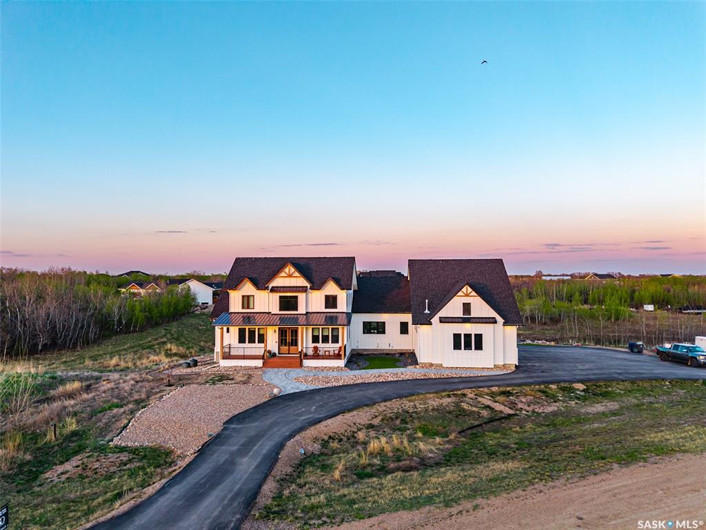 Stunning, custom-built 3789 sqft country home with impeccable attention to detail on a stunning 1.42 acre lot with its own pond surrounded by municipal reserve land. Pause on the covered front veranda to take in the technicolor sunset before you enter the grand foyer with 20 ft ceilings & a bright, sunny office. The open-concept design seamlessly connects the spacious living room, which features vaulted ceilings & a gas fireplace with a beautiful stone hearth, to the chef-inspired kitchen. The kitchen features a large eat-up island, a huge butlers pantry with a second fridge, sink & dishwasher, & tons of storage space. The main-floor primary bedroom is a retreat, offering a spacious walk-in closet and spa-like ensuite. Just through the ensuite, you'll find convenient access to the laundry room, which leads to an additional main-floor bedroom with its own 3-piece ensuite. Upstairs, you'll find 3 more generously sized bedrooms and a 4-piece bathroom with a pocket door to separate the shower and toilet from the sinks, perfect for families. The basement walks-out to a beautiful patio and is roughed in for a pet wash and wet bar. The expansive 4-car garage is every car enthusiast's dream, with Swiss Trax flooring, 12 ft ceilings, high-lift garage doors, & reinforced cabinets. It also features a 100 amp subpanel, a Google Smart Thermostat & central vac. The home offers 3 zones of heating and AC, with motion-activated undermount lighting in the kitchen and stairs. The basement has in-floor heating and its own hot water heater, with 4 inches of foam insulation for maximum energy efficiency. Other high-end features include soft-close pocket doors, Starlink internet, Abode security system, and a Duradeck deck with a natural gas BBQ hookup. Enjoy a landscaped yard with turf, rocks & a fully cleared pond area with a beach, retaining wall, and dock. A 156ft well keeps the pond level maintained. Only 5km from the city! This home must be experienced! Check out the 3D tour.