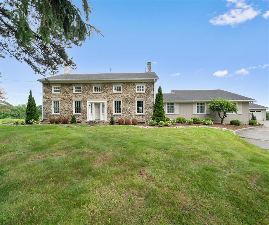 On 15.62 acres of prairie & farmland, this 1856 Cobblestone Farmhouse in Scio Twp has almost 4,000 sq. ft. of up-to-the-minute renovations. Its sophisticated design respects the classic nature of the Four-Square floor plan. It features formal living & dining rooms w/ fireplaces, a home office, updated bath & a chef's kitchen w/ custom cabinets, butcher block counters & stainless. A thoughtful addition that almost doubles the first-floor living space. It has a family room w/ impressive wet bar area, an additional bedroom or den, full bath & laundry. Upstairs is the large Primary bedroom, 3 additional bedrooms, & a renovated hallway bath. The oversized 3-season room w/ fireplace opens to an expansive outdoor living area with multiple patios & firepit area,all overlooking the expansive acreage, w/ regular visits from deer, turkeys & Sandhill cranes. Important updates include windows (2025), French doors to 3-season room (2023), garage doors (2023), well (2018) & 8-zone boiler (2018).