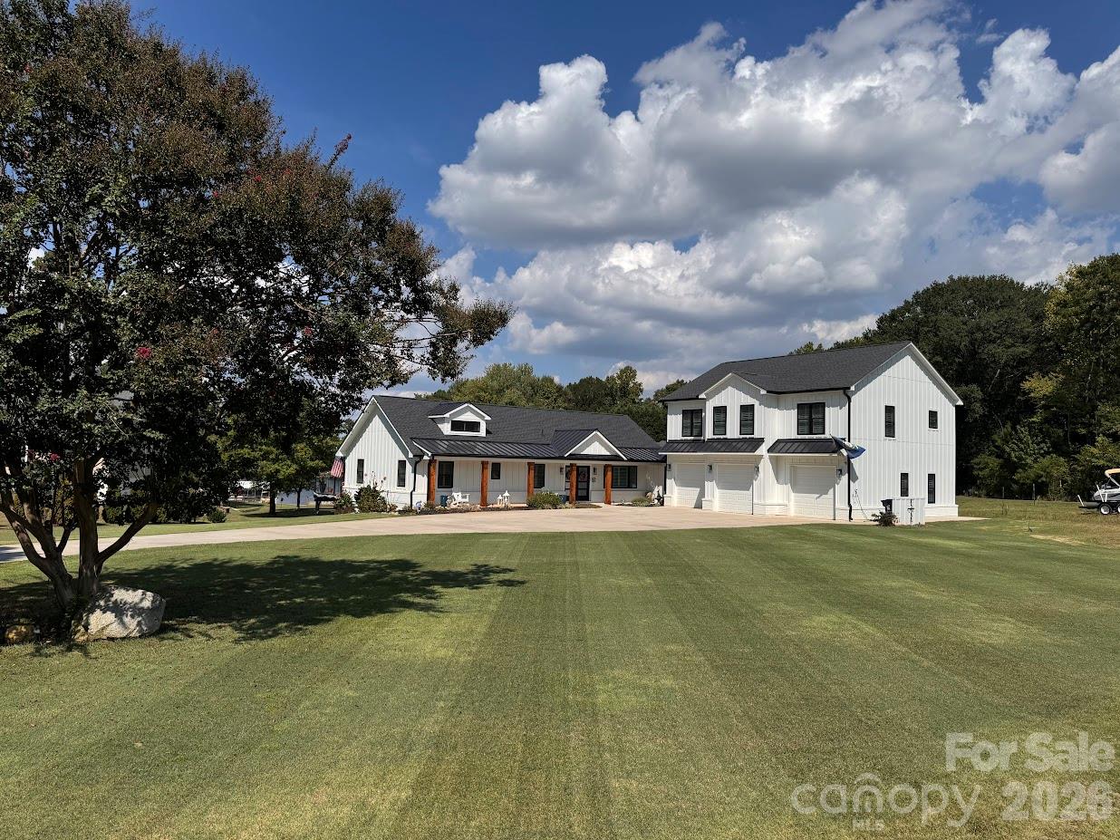 Lake Norman waterfront living at its best on the south end of the lake. Built in 2023 and almost new throughout, this move-in-ready home offers 4866 heated square feet with 5 bedrooms and 7.5 baths. Two primary suites, one on the main level and one in the walk-out basement, where two 12-ft sliders open to a 60x16 covered outdoor living area beneath the main deck. Two kitchens, two laundry rooms, indoor and outdoor bars, custom closets, and porcelain tile in every bath. The 2nd living space above the garage has its own 50-gal water heater and works as a private carriage house, or can be converted to continuous living space with the main home; plans available.On the water: new dock and seawall in 2025, a 10,000-lb boat lift, and dredging completed in 2025 for deep water, currently 8 feet at the front of the slip and 12 feet behind the slip. Fresh water and power at the dock. Shared dock agreement in place with the neighboring property, including right of first refusal to add a roof on this side. Storage shed for your boating gear.Also featuring a 3-car garage with one double bay, 400-amp electrical service, tankless water heater for the main house, irrigation system, and city water and sewer. This is one you do not want to miss. Take lake life to the next level!