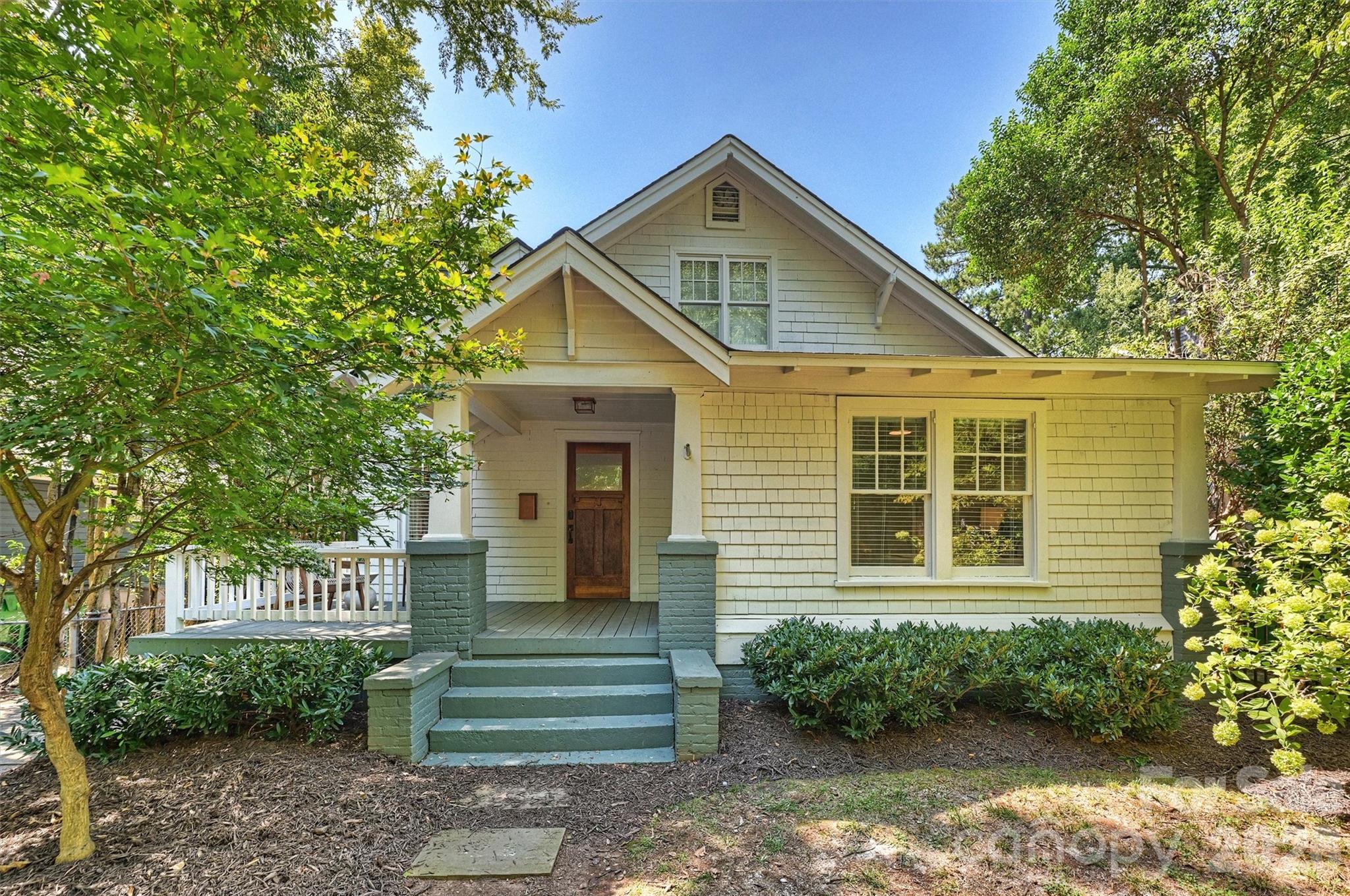 Classic Dilworth charm meets thoughtful updates in this beautifully maintained 1925 bungalow on one of the neighborhood’s most walkable streets. The inviting front porch opens to a warm, character-filled interior with hardwood floors, a fireplace, and an open-concept kitchen and dining area. The updated kitchen is designed for both everyday living and entertaining, featuring custom cabinetry, a large marble island, and commercial-grade appliances including a 48-inch gas range and dual ovens. The main-level primary suite offers a spacious bedroom and beautifully updated bath with double vanity, separate shower, and soaking tub. Two additional bedrooms and baths on the main level provide flexibility for guests, an office, or additional living space. Upstairs, a generous fourth bedroom or bonus room with a full bath offers excellent flexibility. Outside, the large rear deck overlooks the backyard, creating a private setting for outdoor living and entertaining. A long driveway provides ample off-street parking.  Home also offers a new HVAC system and duct work. Ideally located in the heart of Dilworth with easy access to East Boulevard, South End, the light rail, parks, restaurants, and neighborhood shops.