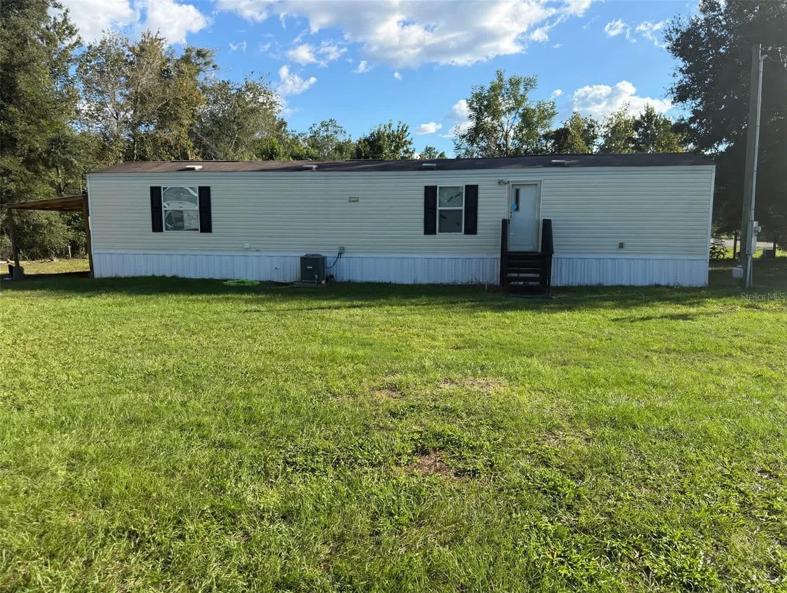 Two lots, one price. This 2019 TRU manufactured home (14x60, 840 sq ft, 2 bedrooms, 2 full baths) sits on its own land in Ocala Estates, and the vacant lot next door is included: 0.49 acres total, owned outright — no lot rent, no HOA. A Cherokee travel trailer is included and conveys with the sale. Private well and septic, Flood Zone X. Two lots, a 2019 home, and a travel trailer in one package — come walk the land and see everything that's included.