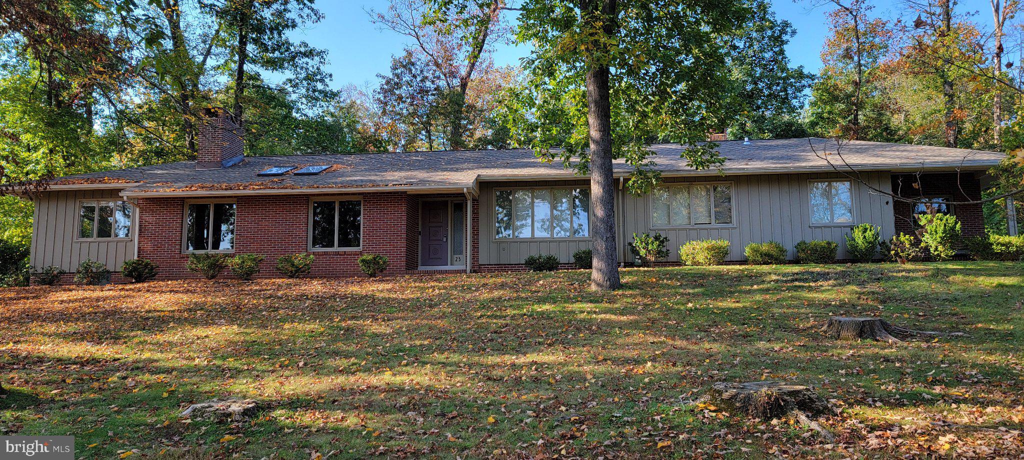 Professional photos/video are coming soon. Set on 1.6 wooded acres in Hopewell Township's established River Knoll neighborhood, this distinctive mid-century ranch offers an appealing combination of architectural character, generous living spaces, and natural surroundings. Its long, low roofline, attractive combination of brick and vertical siding, and prominent masonry chimney reflect the understated style of classic mid-century residential design. Inside, the home's thoughtful design takes full advantage of its setting, with abundant natural light, front-to-back views, and large roof overhangs that provide shade from the summer sun while allowing daylight to fill the living spaces. The impressive great room features a soaring ceiling with oversized skylights, beautifully finished hardwood floors, and a substantial raised-hearth fireplace that anchors the space. Hardwood flooring continues throughout the three bedrooms, while a dedicated home office provides a comfortable place to work or study. The updated kitchen and adjoining dining area connect to a spacious sunroom, where nature feels especially close and the patio is just steps away. Three porches offer additional places to sit, relax, and enjoy the property from different perspectives. Outside, raised vegetable garden beds protected by deer fencing provide a ready-made opportunity for gardening. Additional features include two full bathrooms, an unfinished basement offering ample storage and potential for future use, an attached two-car garage, a 30-amp generator transfer switch, and a roof that's just two years old. With approximately 2,411 square feet of living space, this home combines the ease of single-level living with the openness and architectural interest that make mid-century homes so appealing. Conveniently located near Pennington, Lambertville, Washington Crossing, and the Princeton area, this is a home where the design, natural light, and surrounding landscape come together particularly well. This home is also available for lease at $3,895 per month plus utilities.